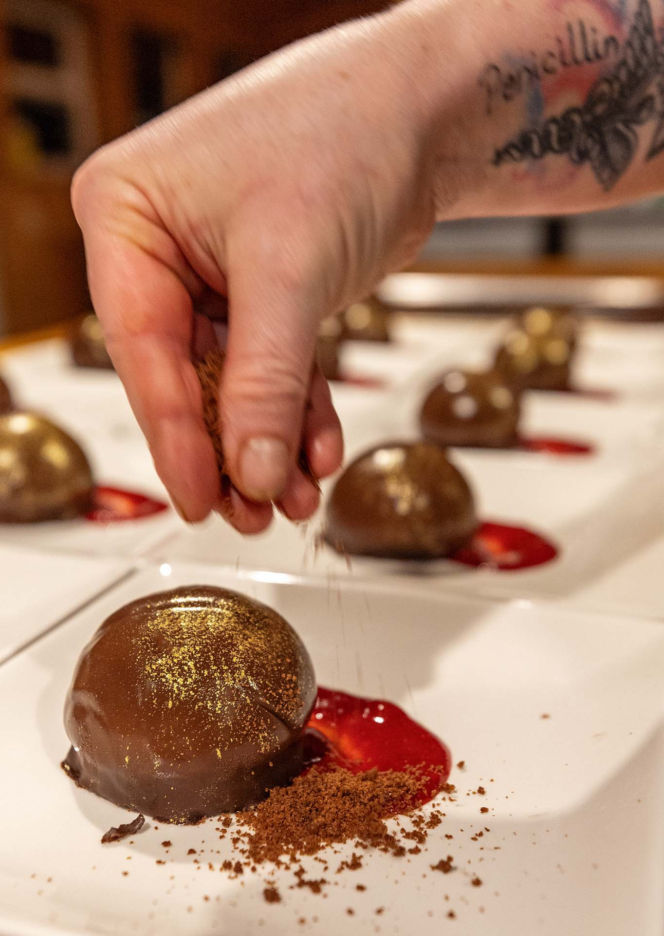 Chocolate domes dusted by hand for dessert