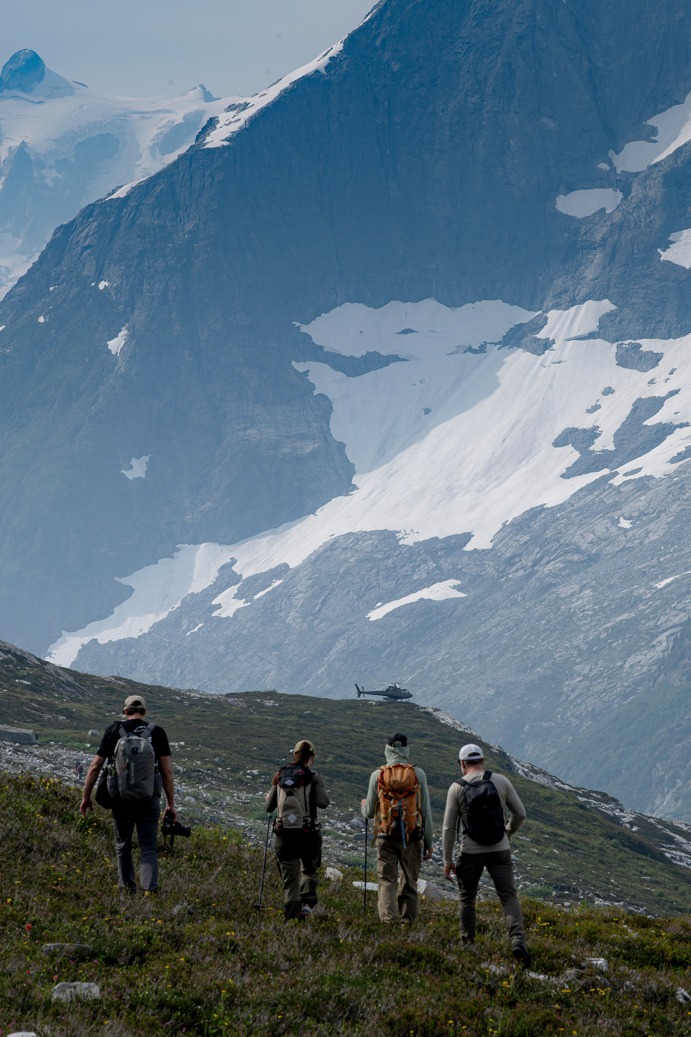 Hikers crossing the alpine as the helicopter passes
