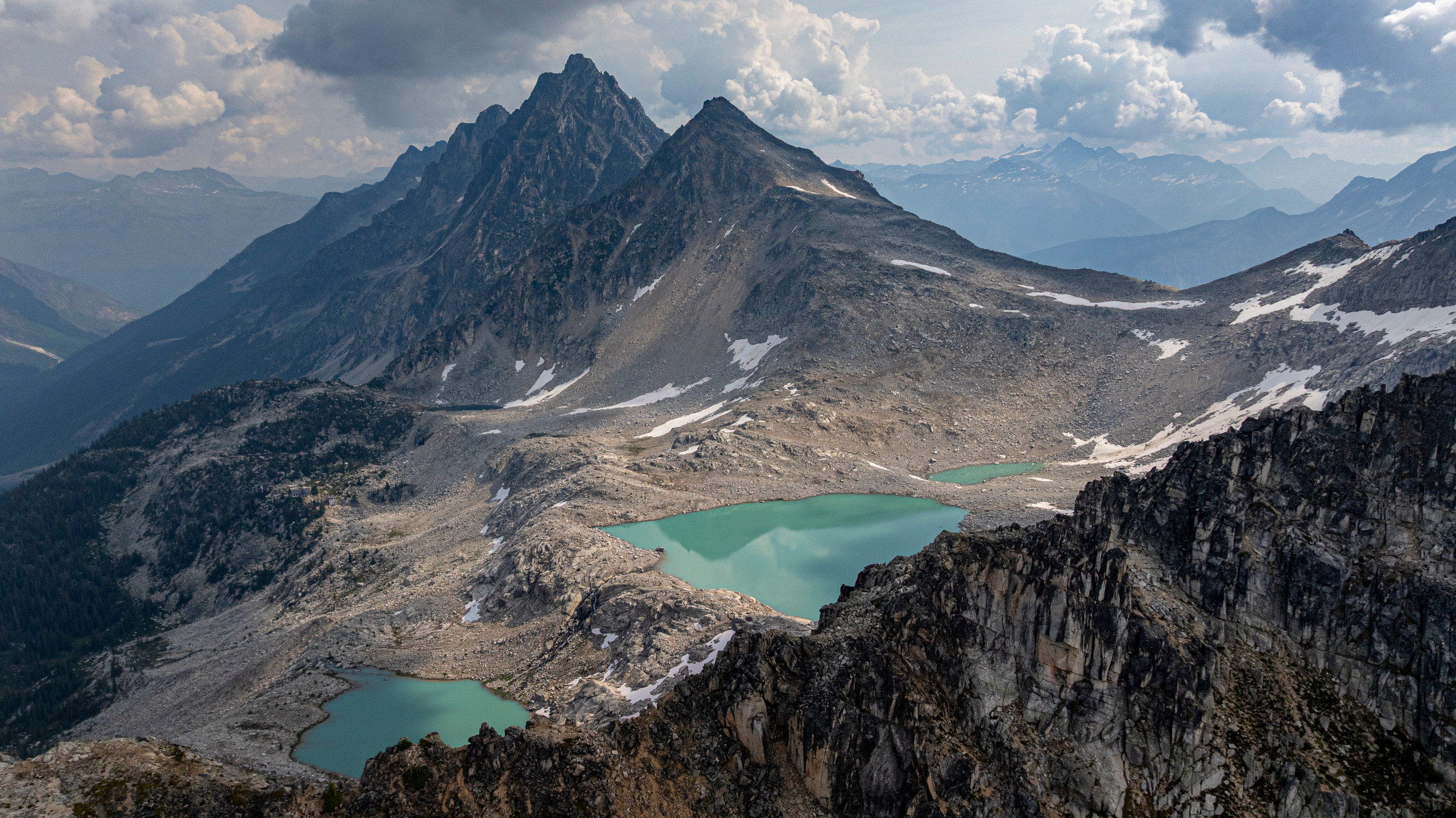 Two turquoise alpine lakes below a pair of granite peaks