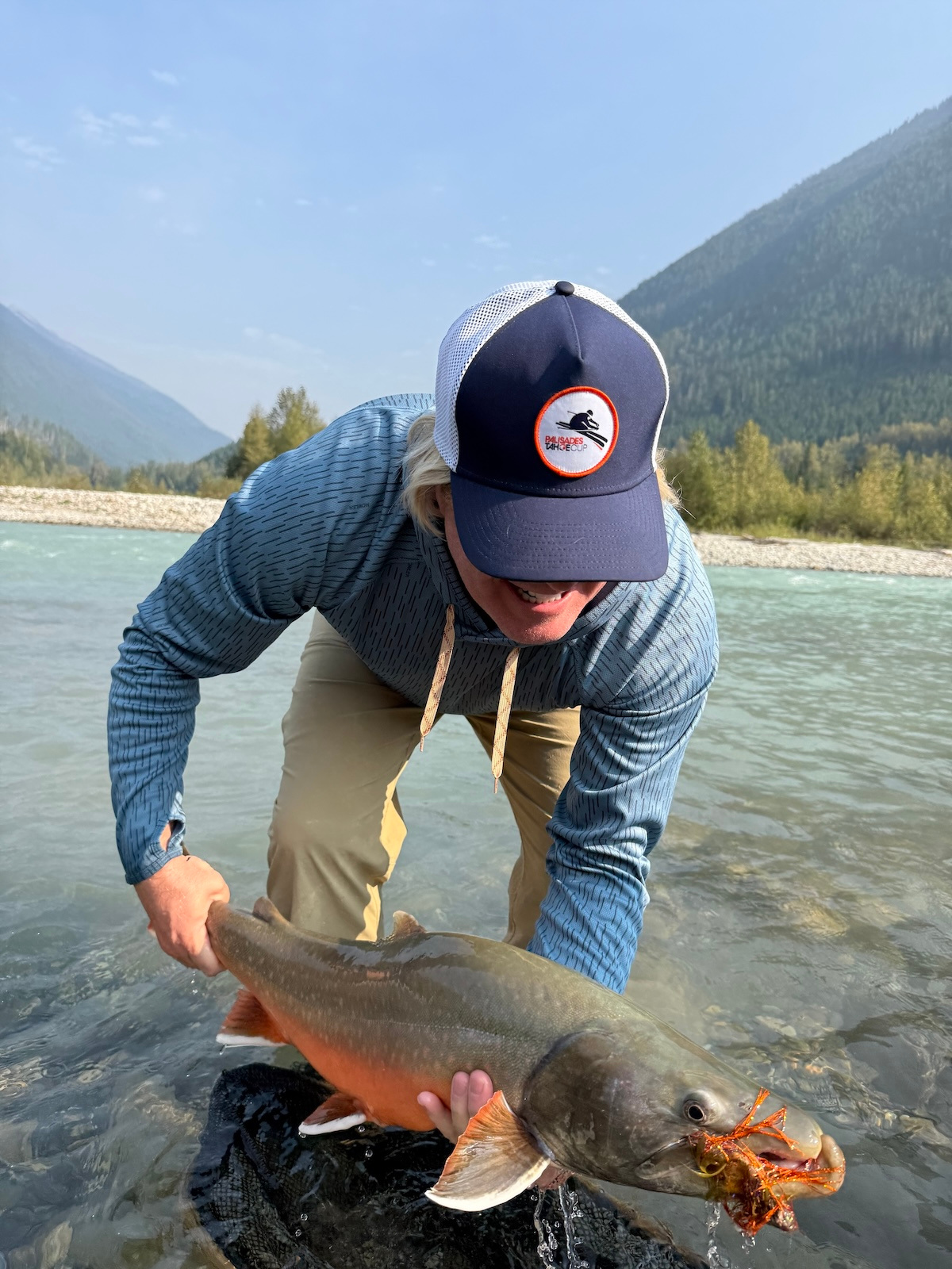 A bull trout, held for a moment in the river