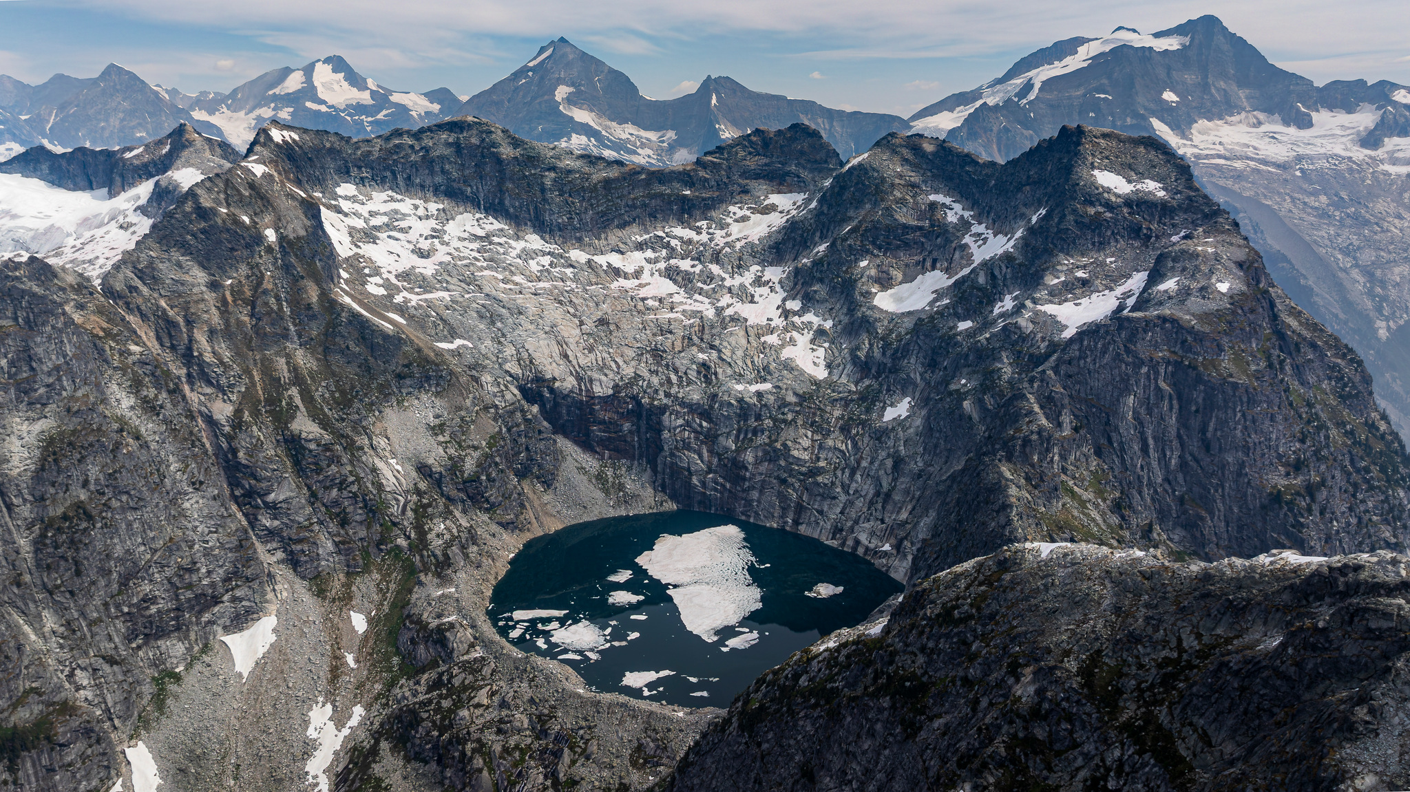 A half-frozen lake in a granite basin