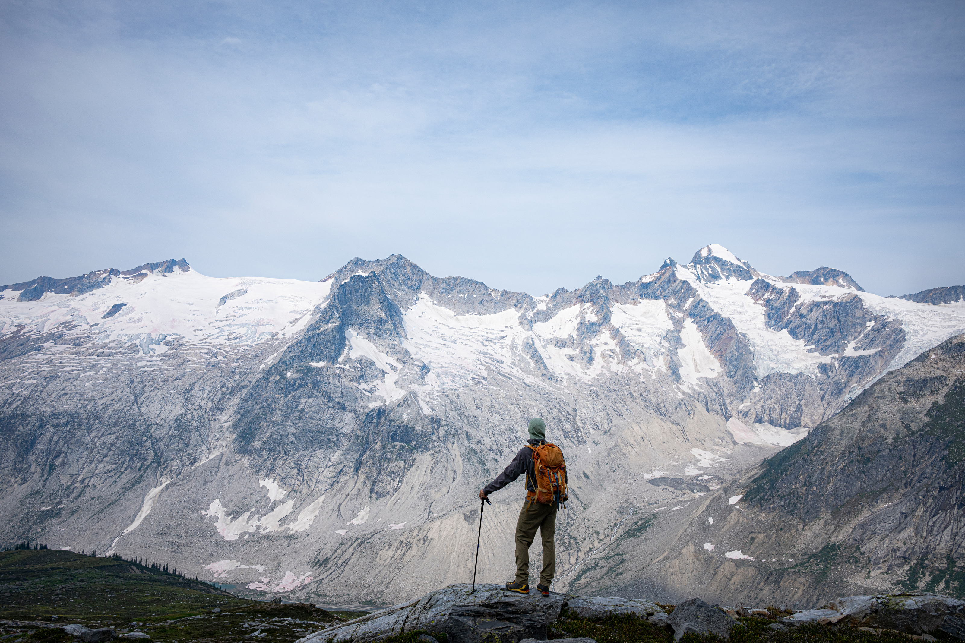 A hiker looking out over glaciers in the Selkirks