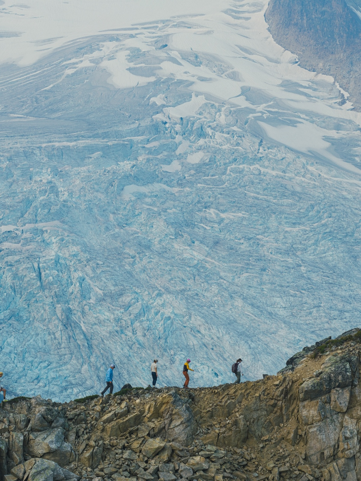 Walking the moraine above a blue, crevassed glacier