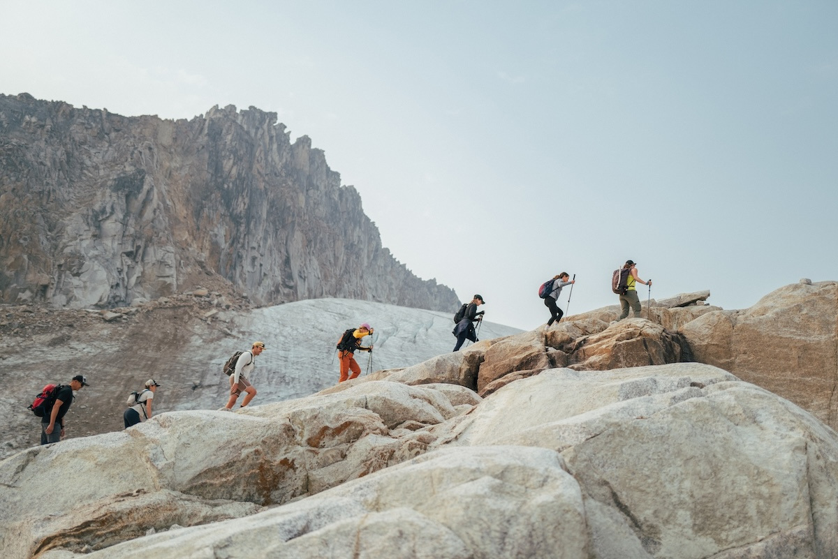 A group crossing polished granite toward the glacier