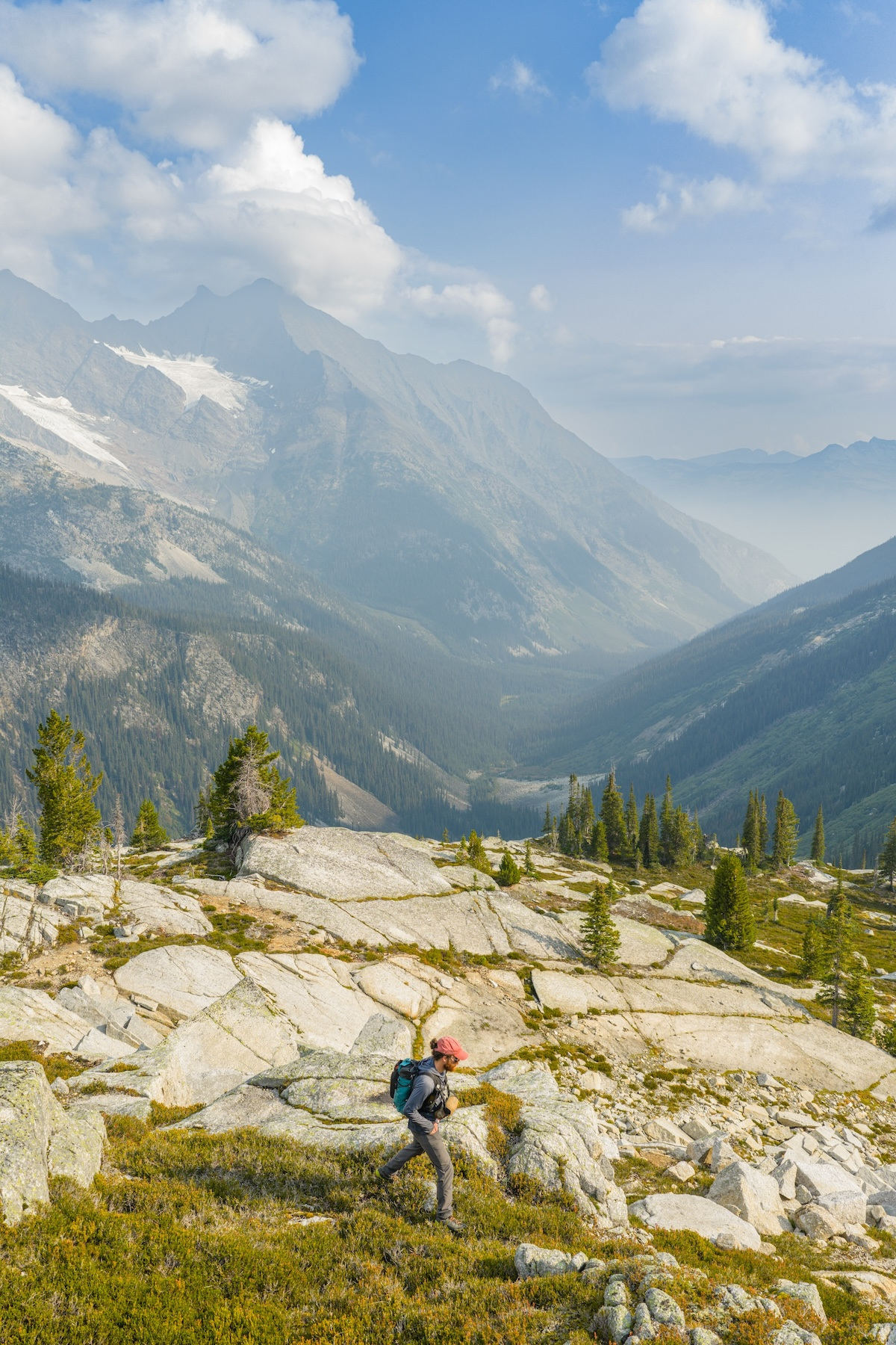 A hiker on the granite slabs above the valley