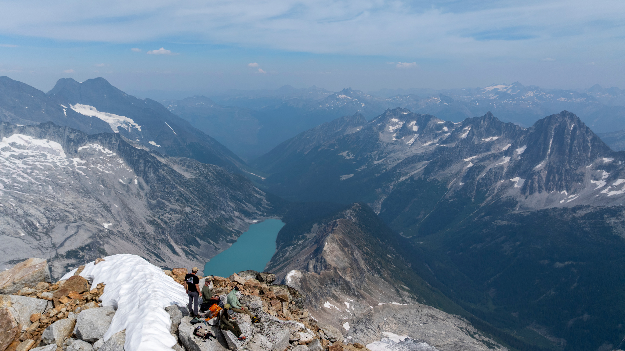 A rest on the summit, a turquoise lake far below