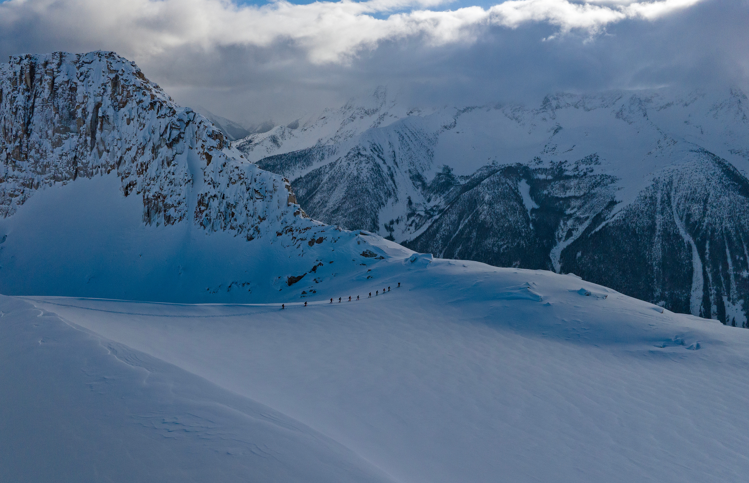 Ski tourers crossing an alpine bowl in the Battle Range