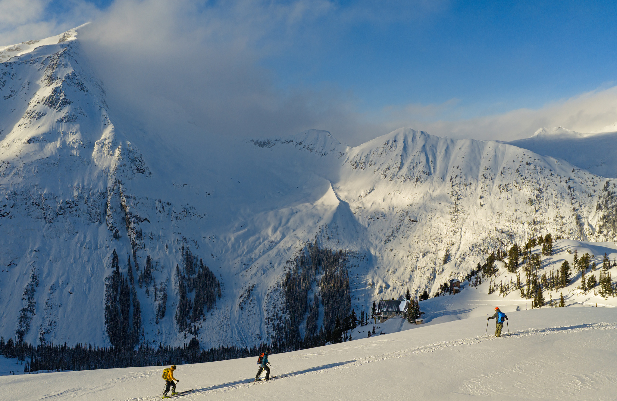 Setting out on skins below a wide, sunlit cirque