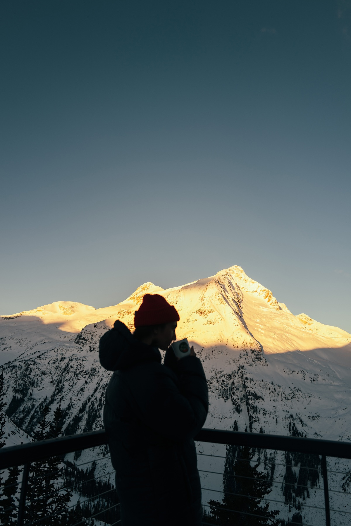 Coffee on the deck as the sun catches the peak across the valley