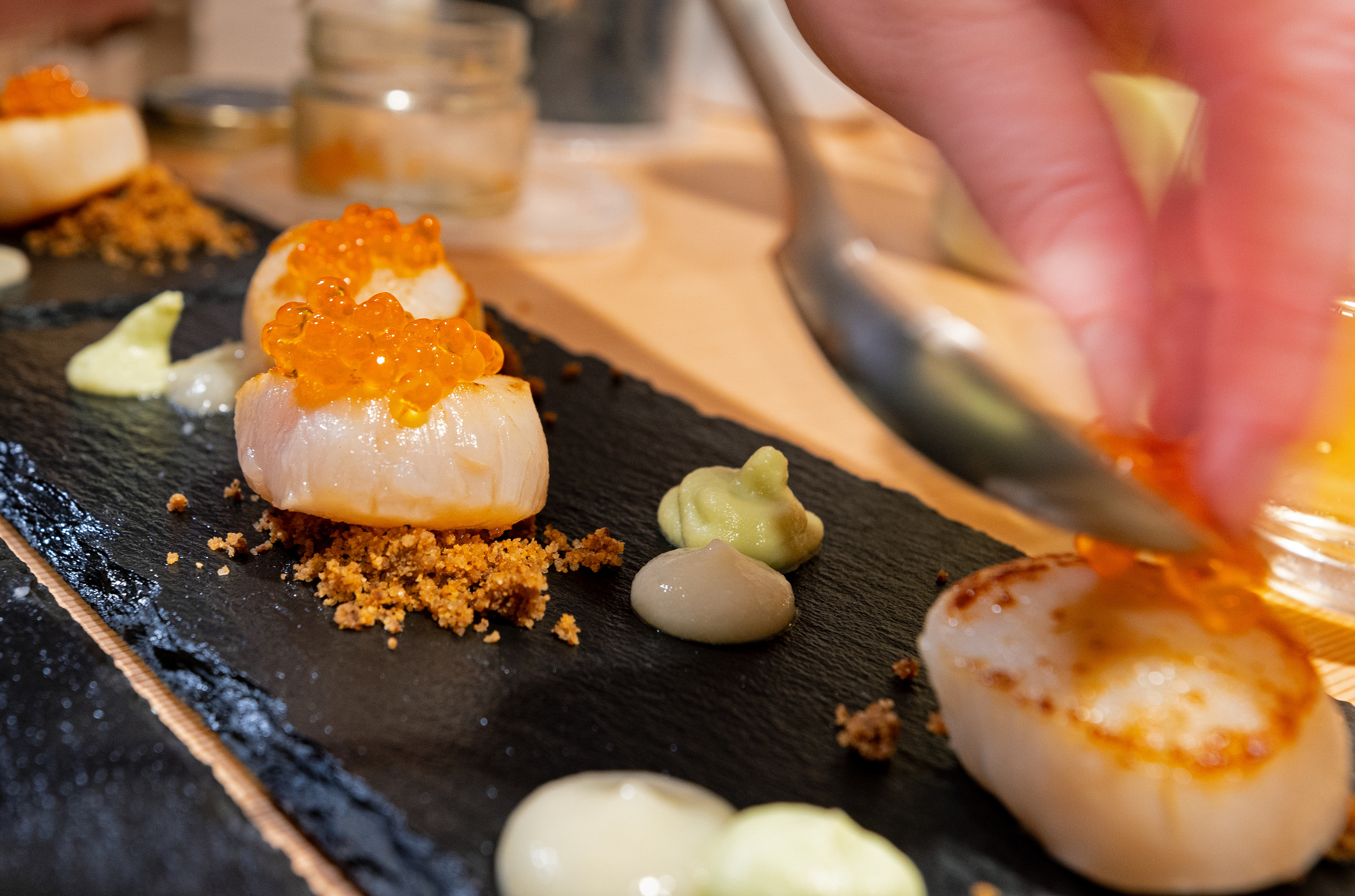 Seared scallops being plated for dinner at Battle Abbey