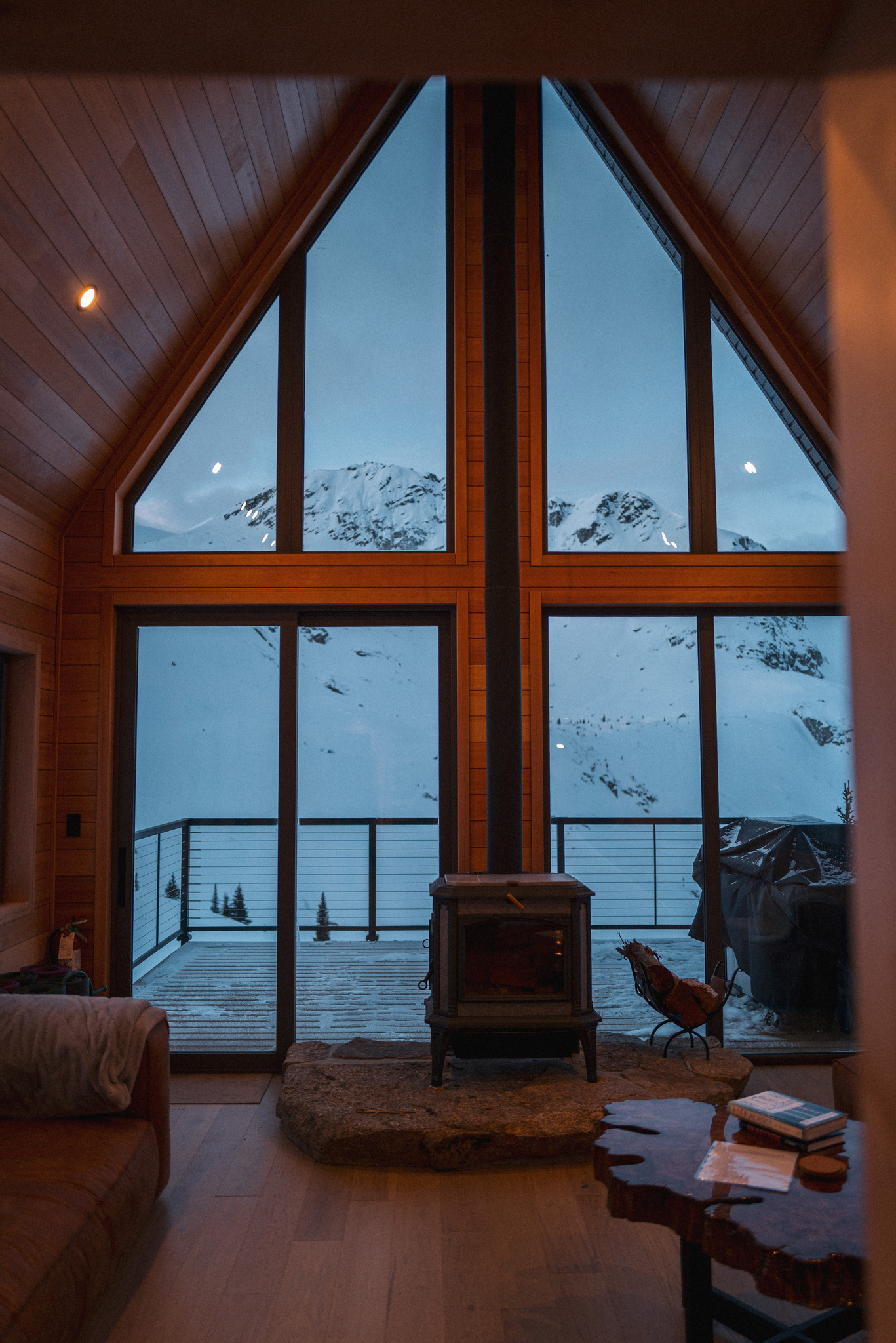 The lounge, with its A-frame windows and wood stove