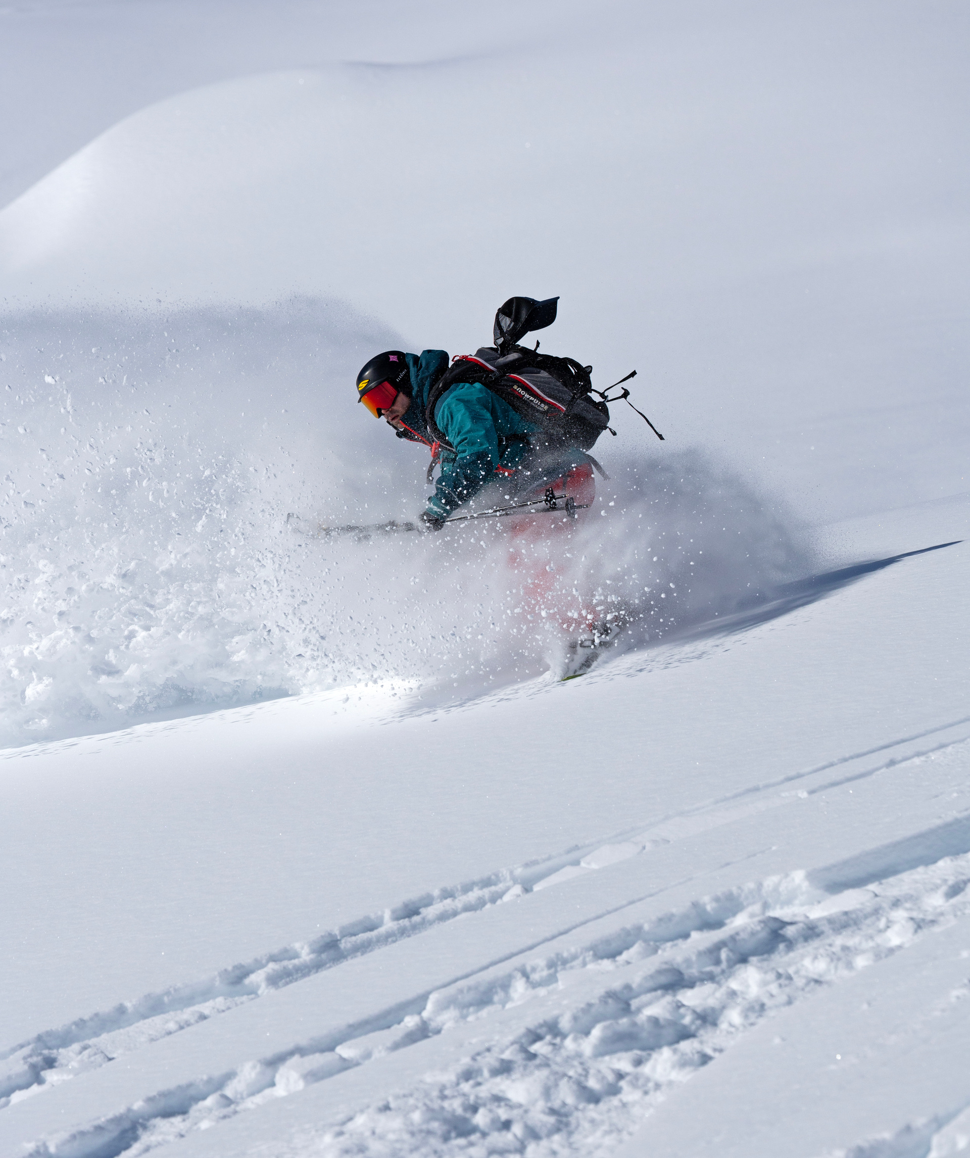A skier turning through deep powder below Battle Abbey
