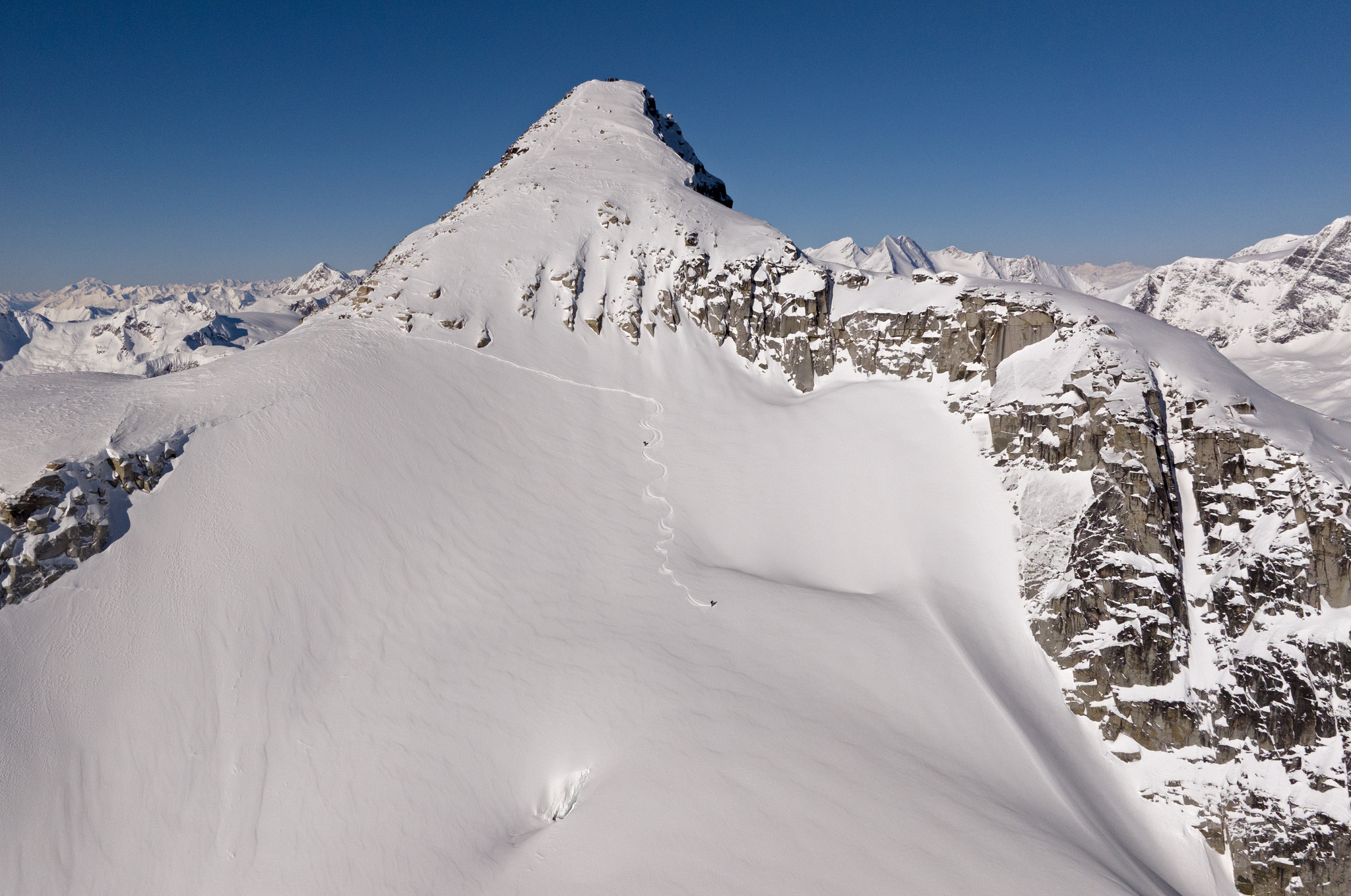 A lone skin track leading up to a rocky summit