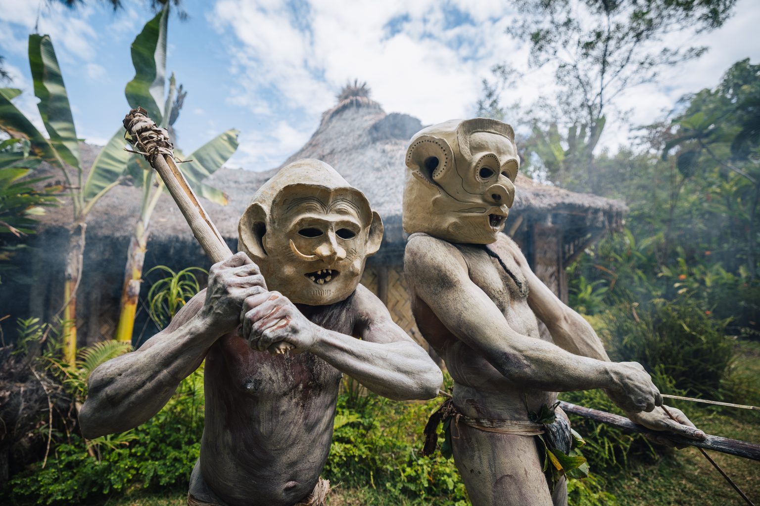 Asaro Mudmen in clay masks outside a village in the Eastern Highlands