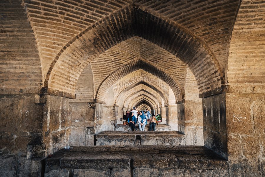 Families sitting in the arches beneath the Khaju Bridge over the Zayandeh Rud, Isfahan