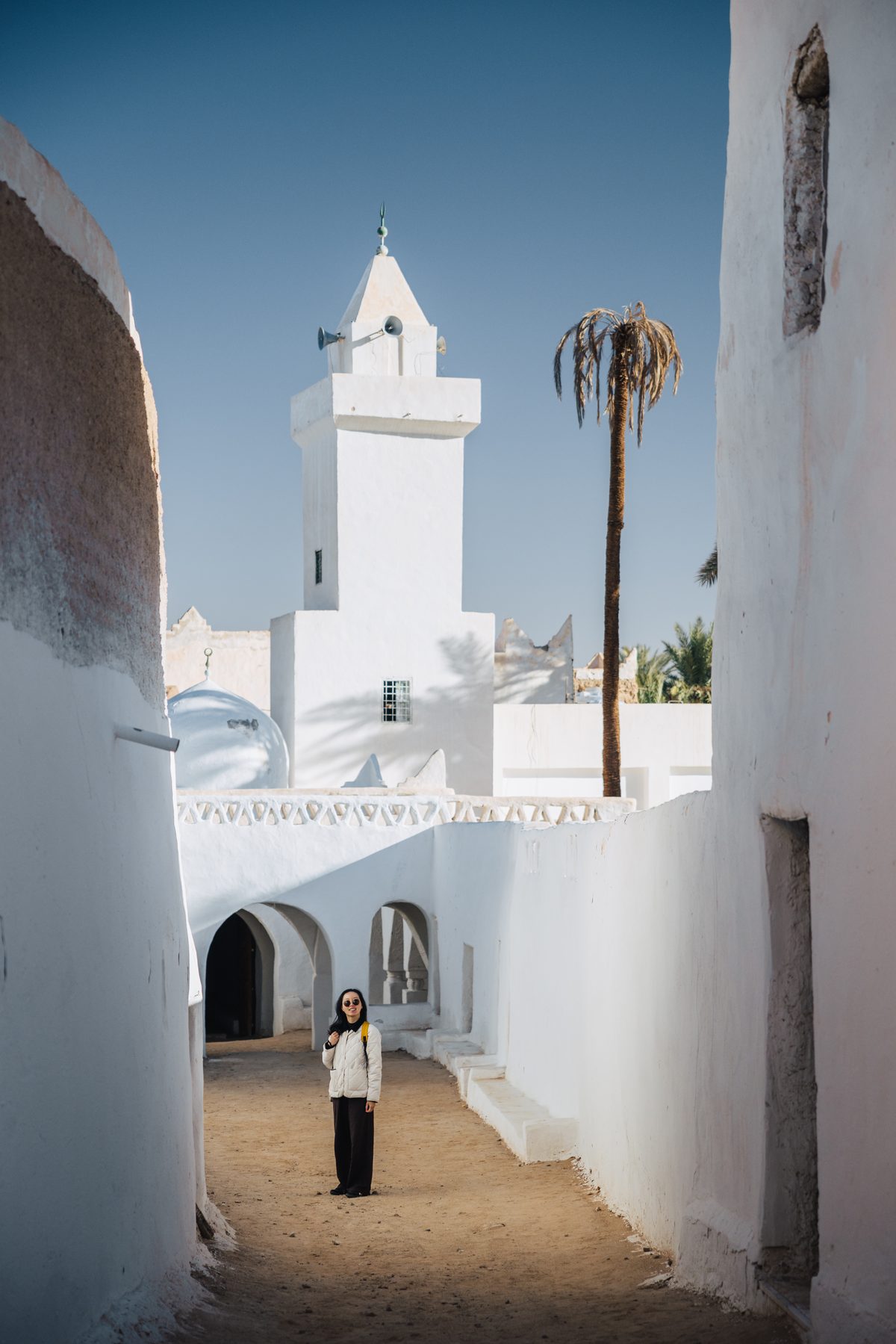 A traveller in a whitewashed lane of the old city of Ghadames, Libya
