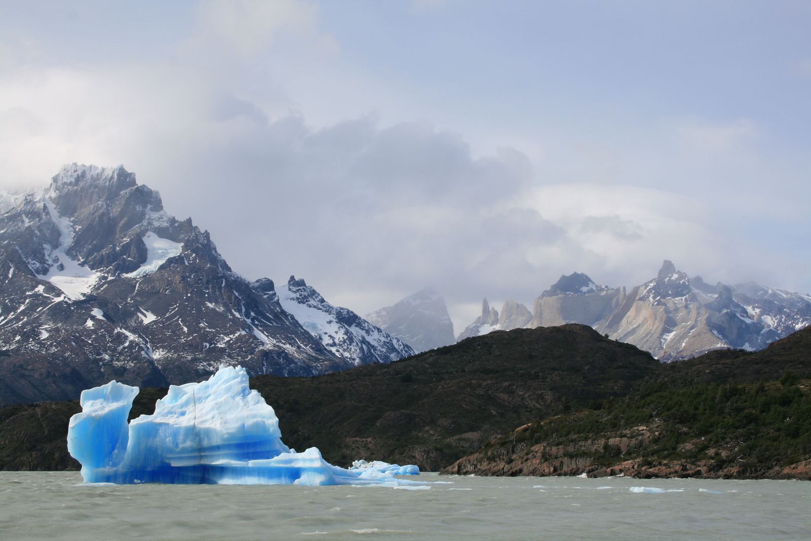 An iceberg adrift on Lago Grey beneath the peaks of the Paine massif, Chile