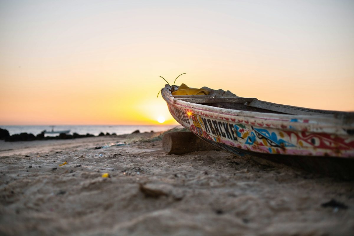 Colorful pirogue boat on West African beach at sunset — Ghana, Benin, Togo expedition
