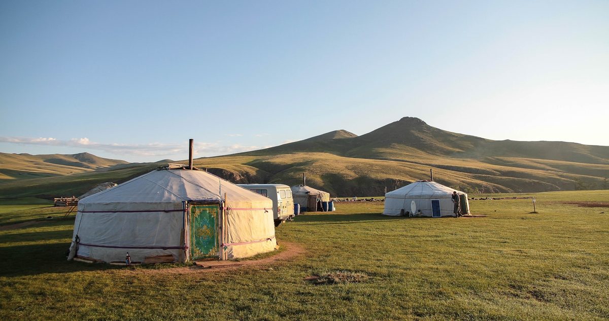 Traditional Mongolian ger camp on the open steppe at sunset