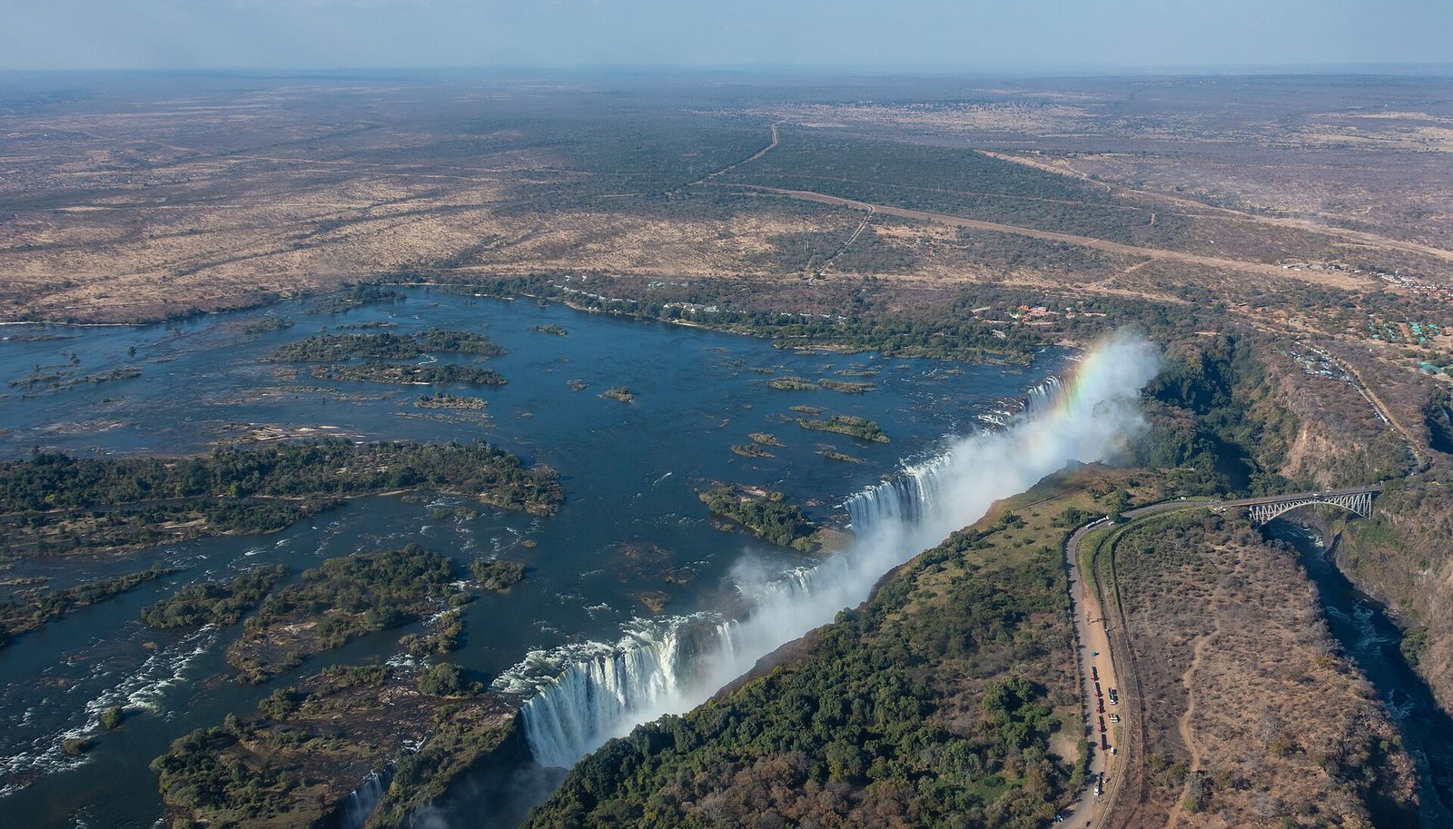 Victoria Falls and its gorge from the air, with a rainbow in the spray