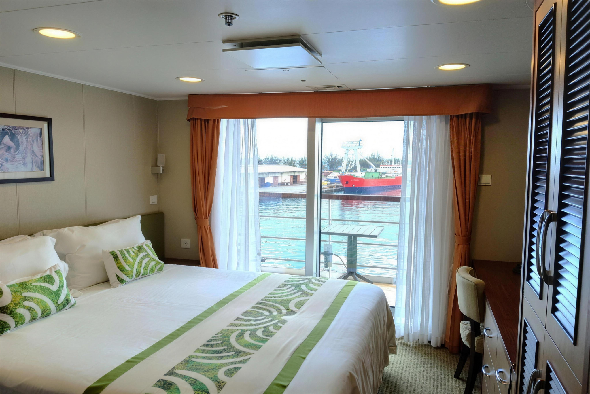 A Deluxe cabin, with a double bed and a glass door to the balcony