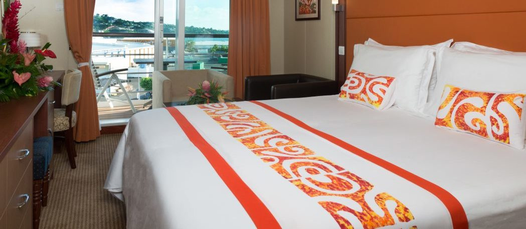 A Junior Suite with a balcony, with a king bed and a glass door to the balcony
