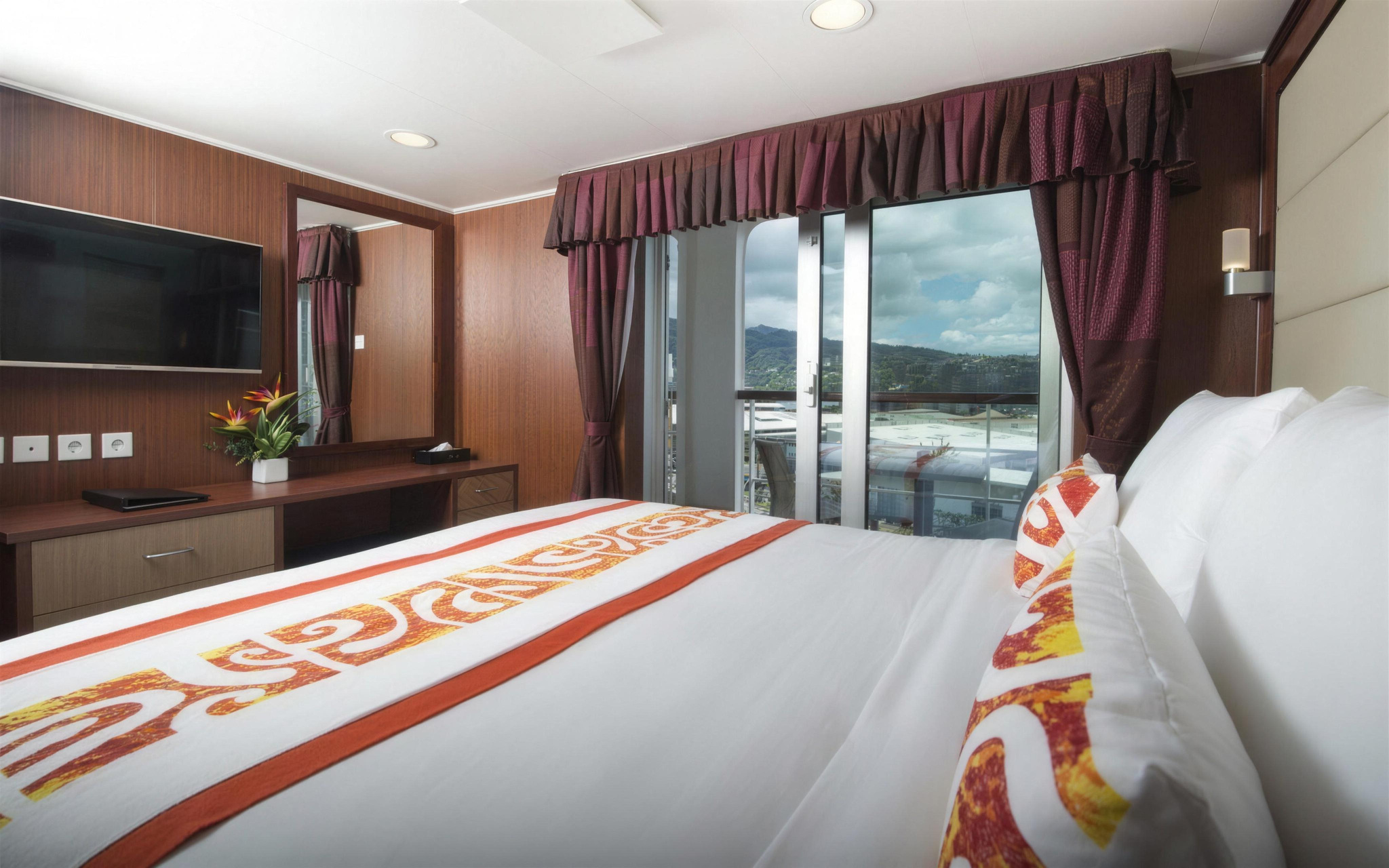 The Presidential Suite's bedroom, with a king bed and a glass door to the balcony