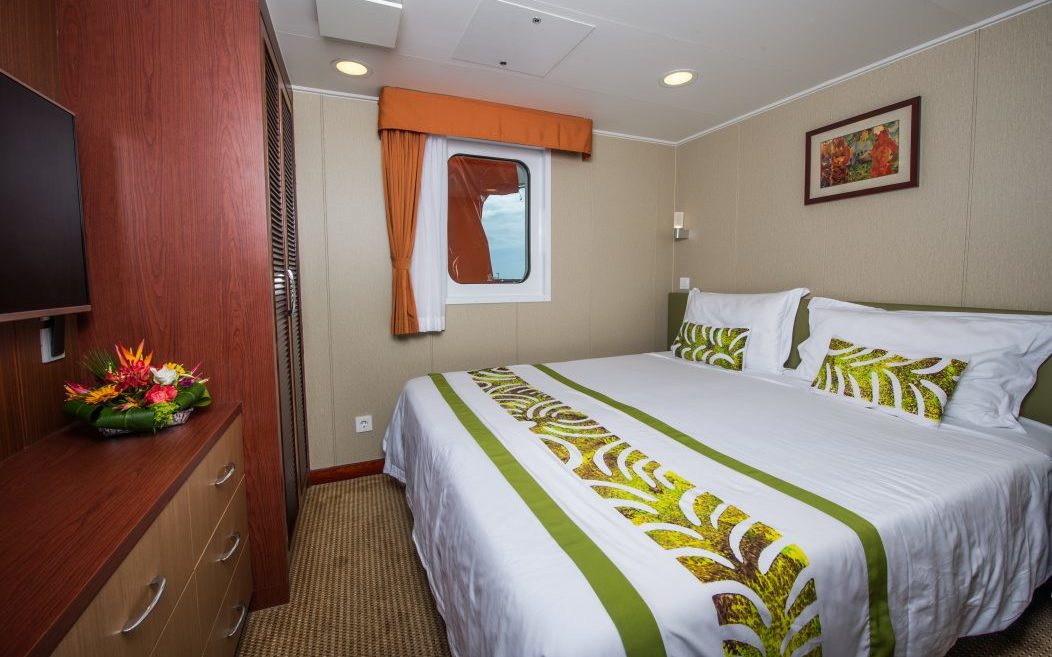 A Stateroom with an obstructed view, with a double bed and a small window