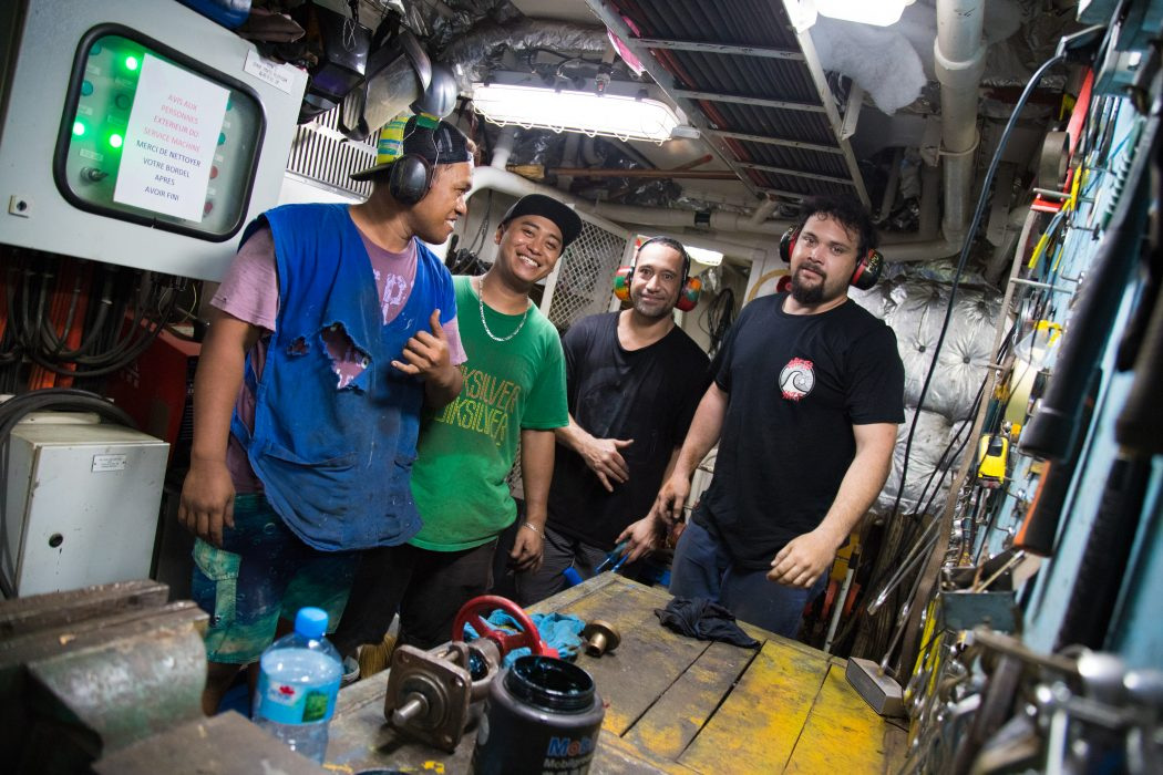 Four of the engine-room crew at a workbench below decks