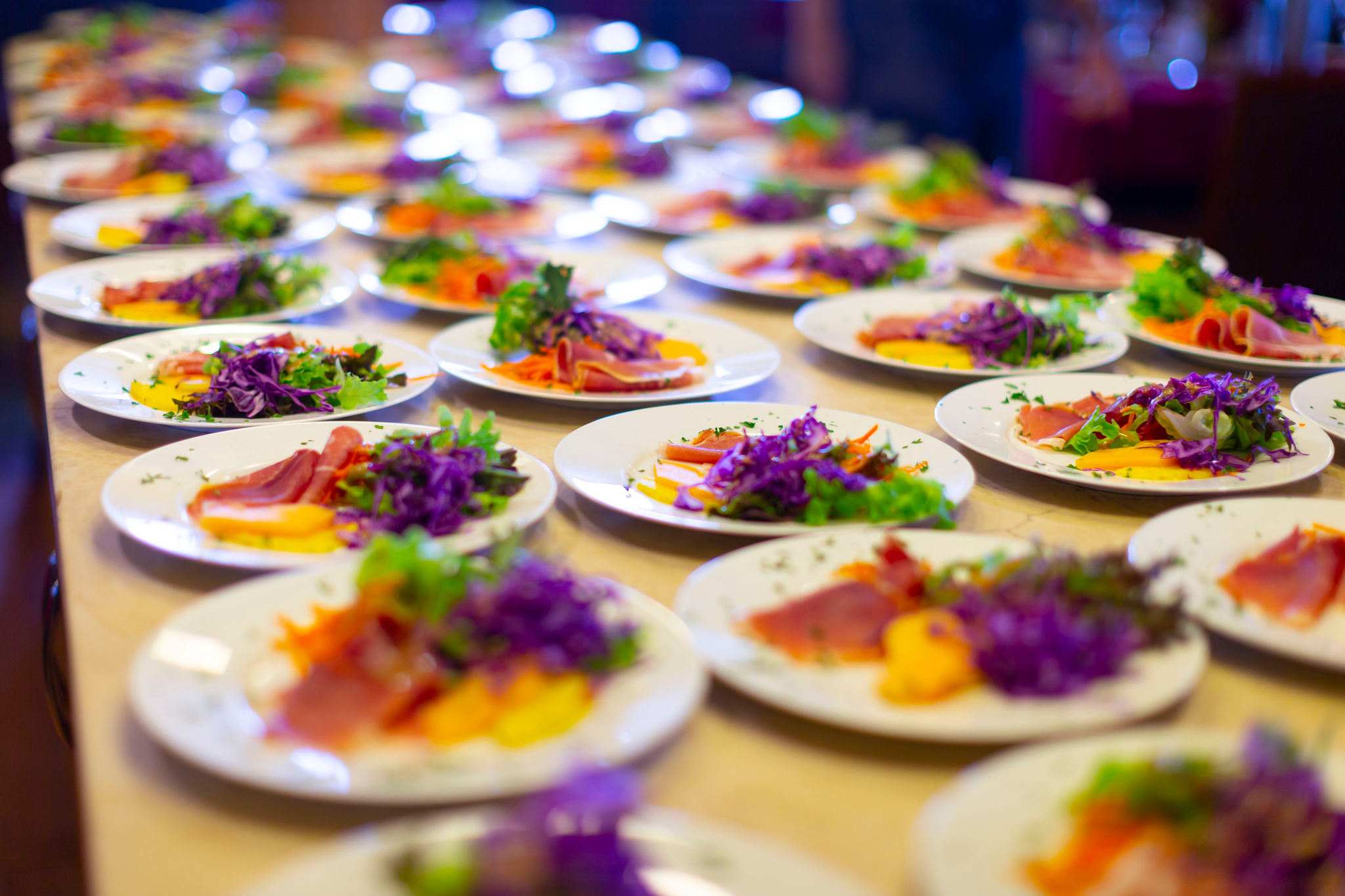Rows of plated starters of cured fish and red cabbage salad