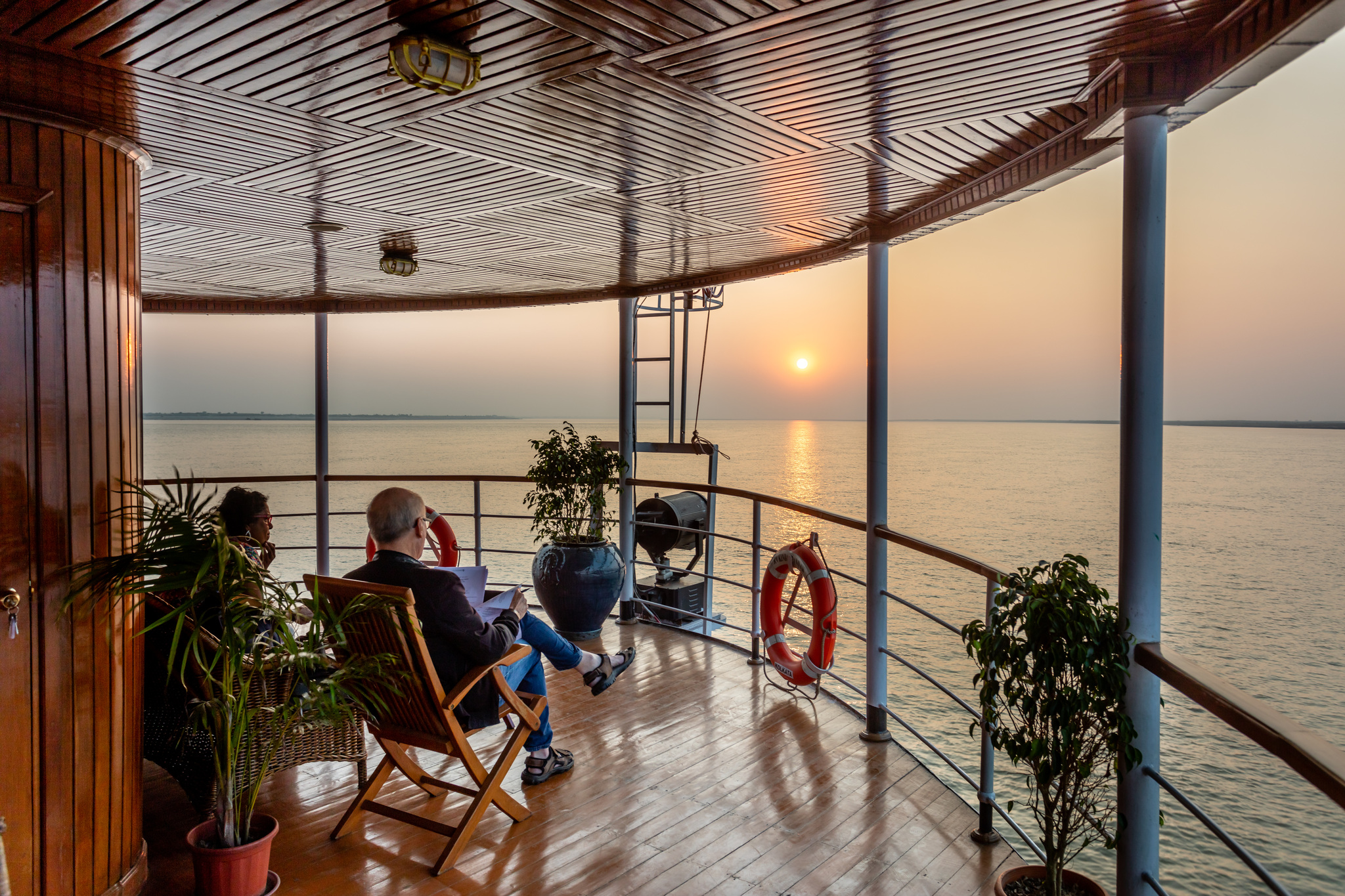 Guests reading on the bow deck as the sun goes down