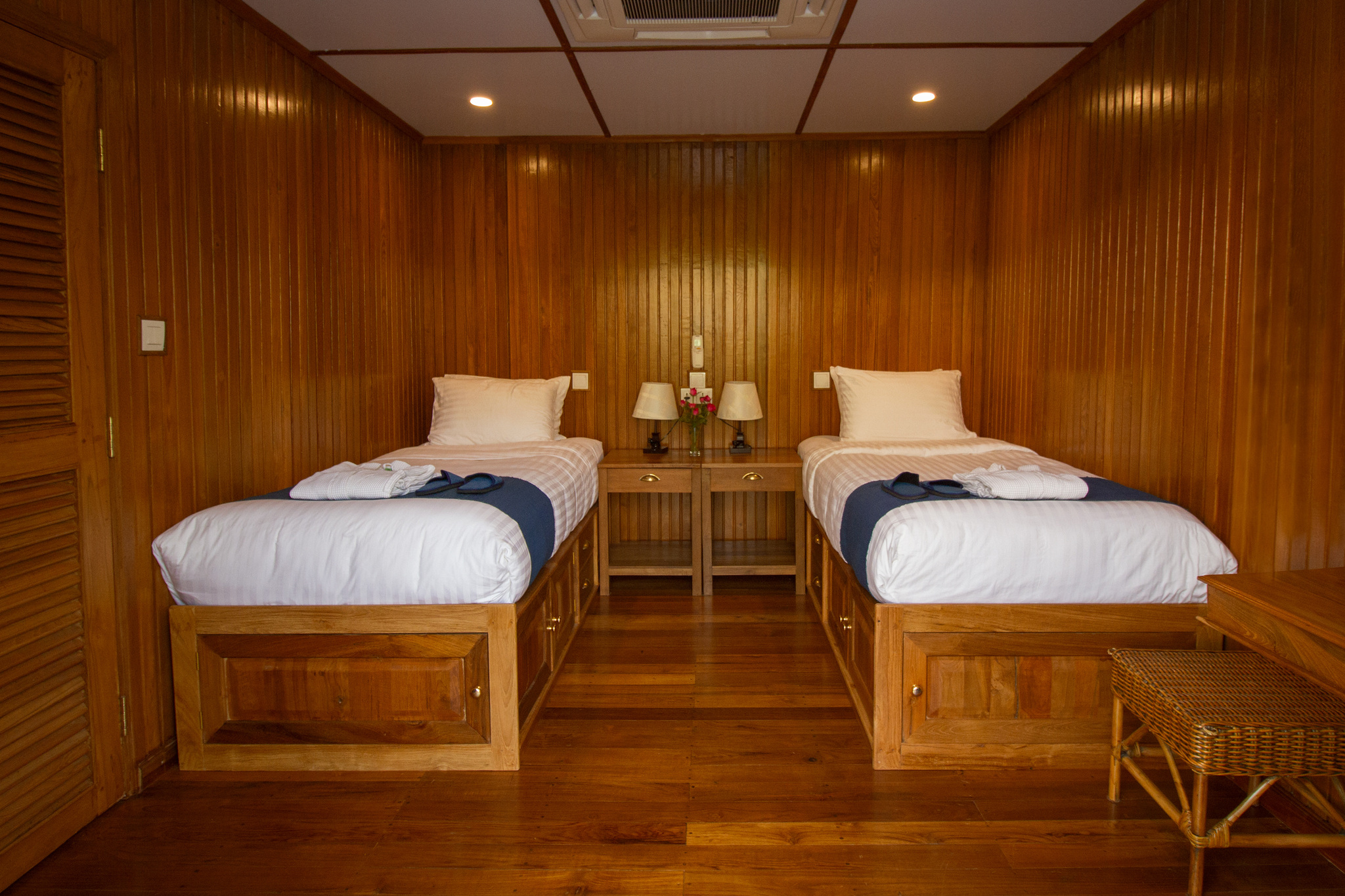 A twin cabin in teak, with two beds made up in white