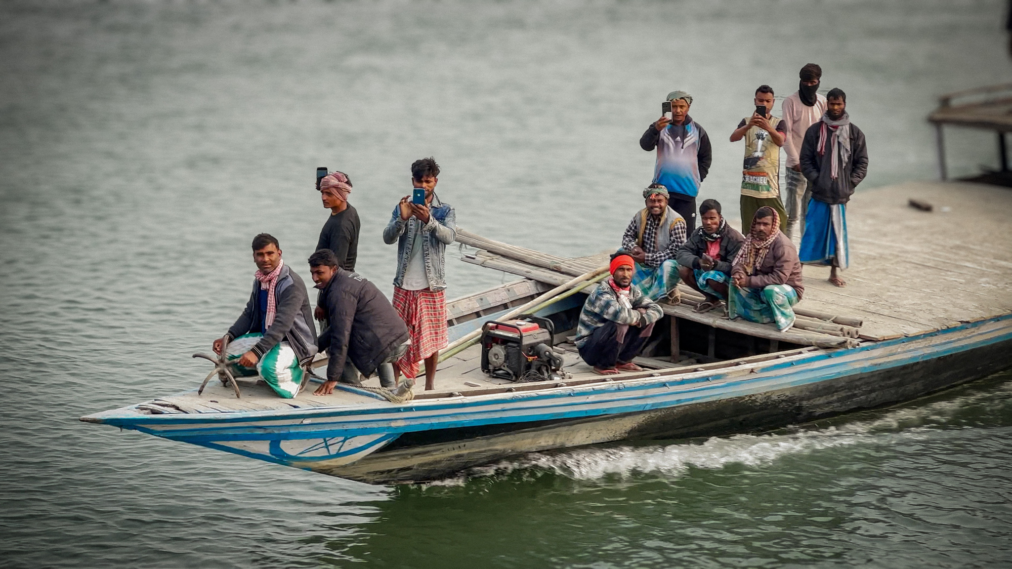 Villagers crossing the river in a long wooden boat