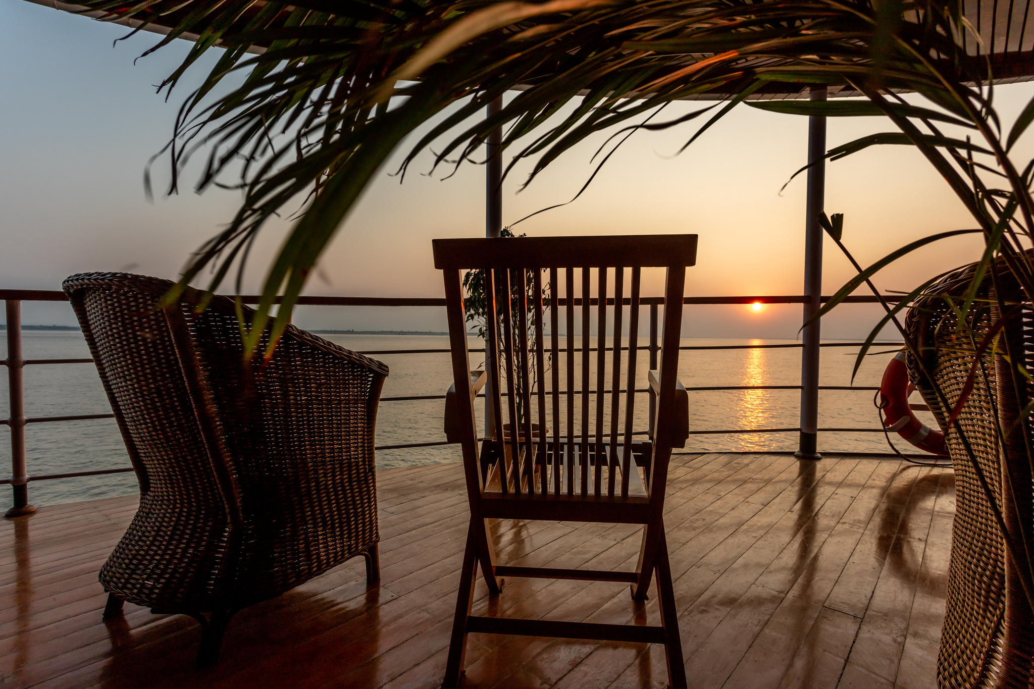 Rattan chairs on deck facing the sunset