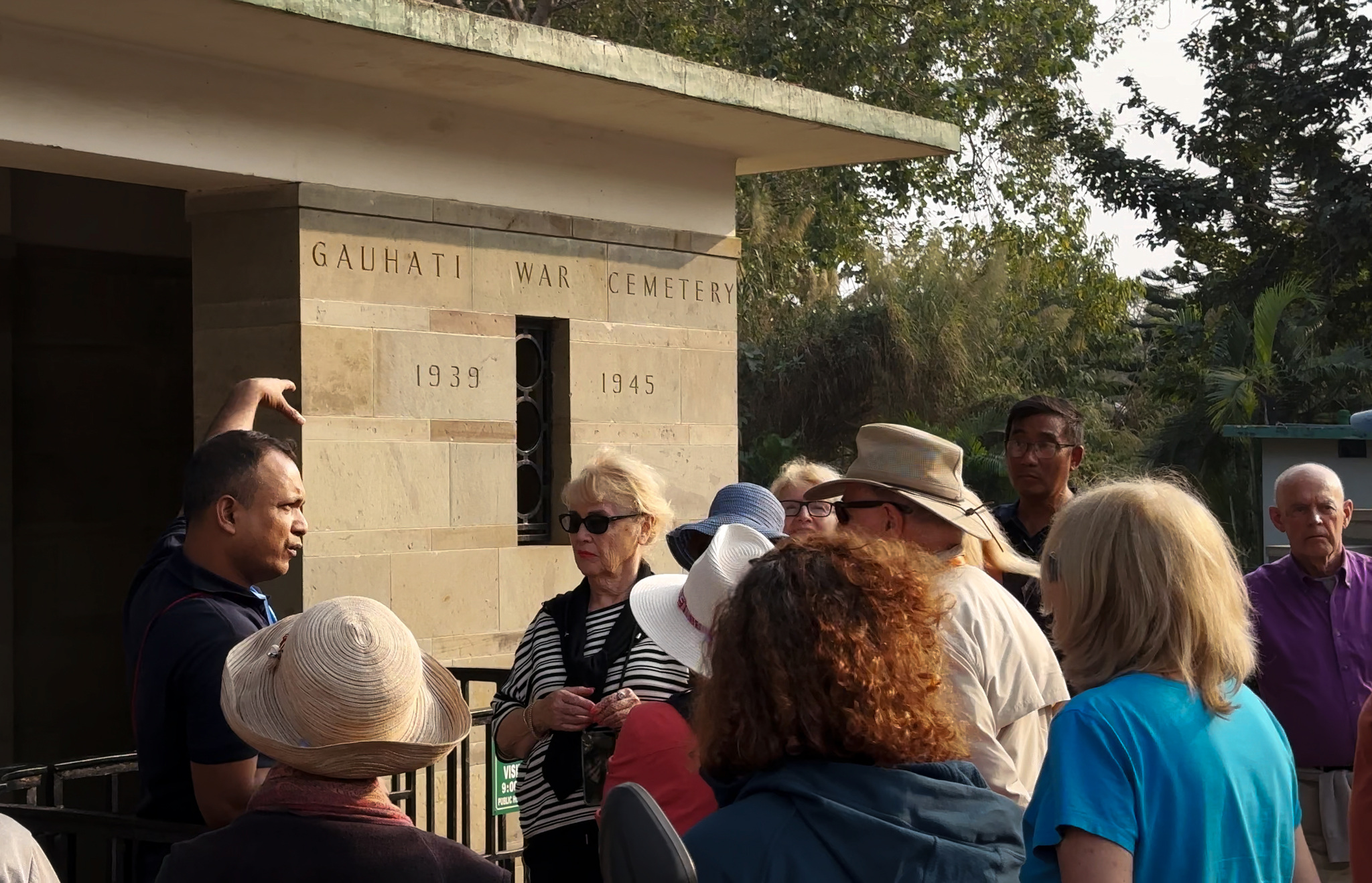 A guide with guests at the entrance to the Guwahati War Cemetery