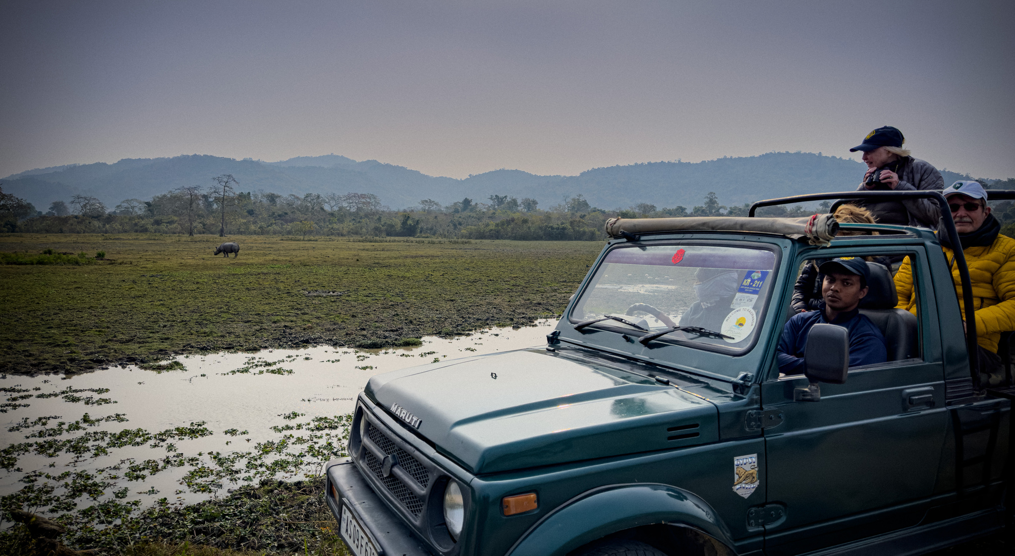 Guests in a safari jeep beside a Kaziranga wetland
