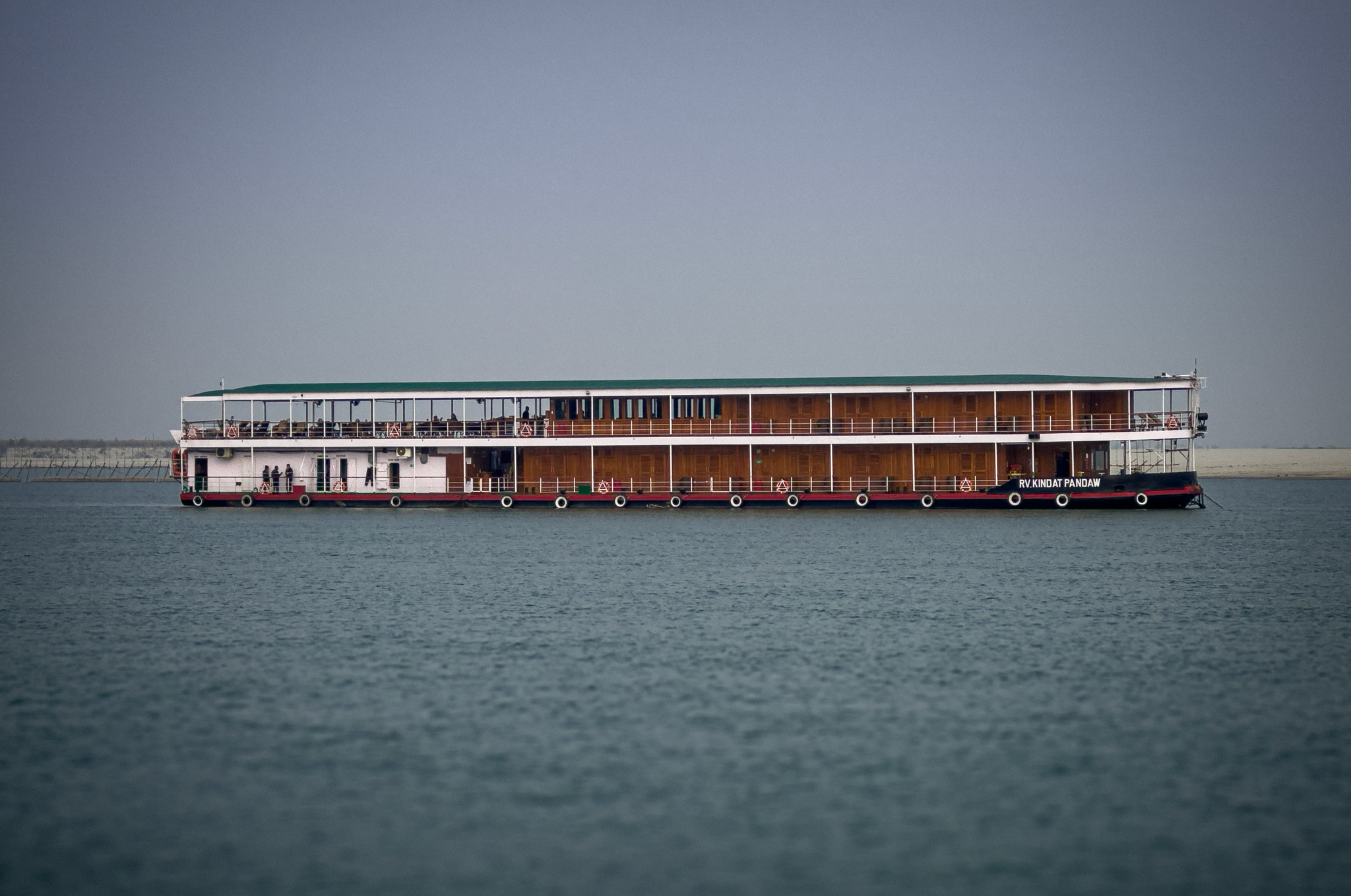 The ship on a grey morning, the river flat around her