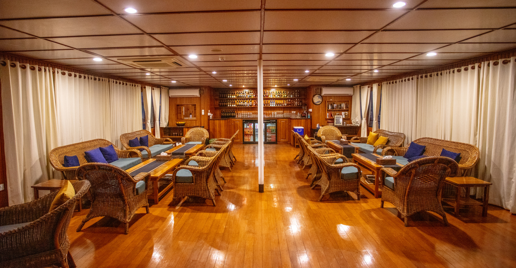 The saloon bar, with rattan armchairs on a teak floor