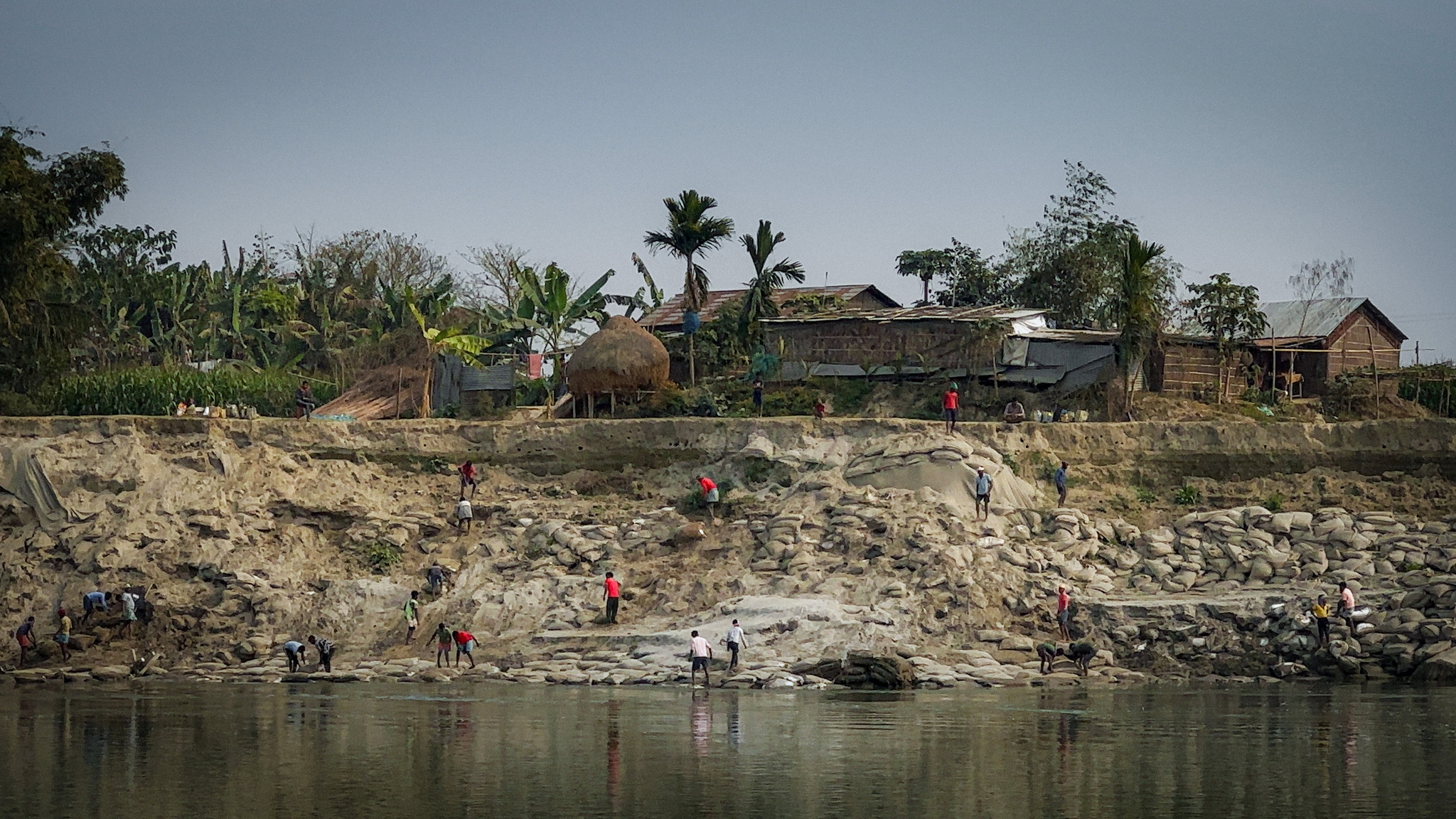 Houses above a crumbling bank of the river