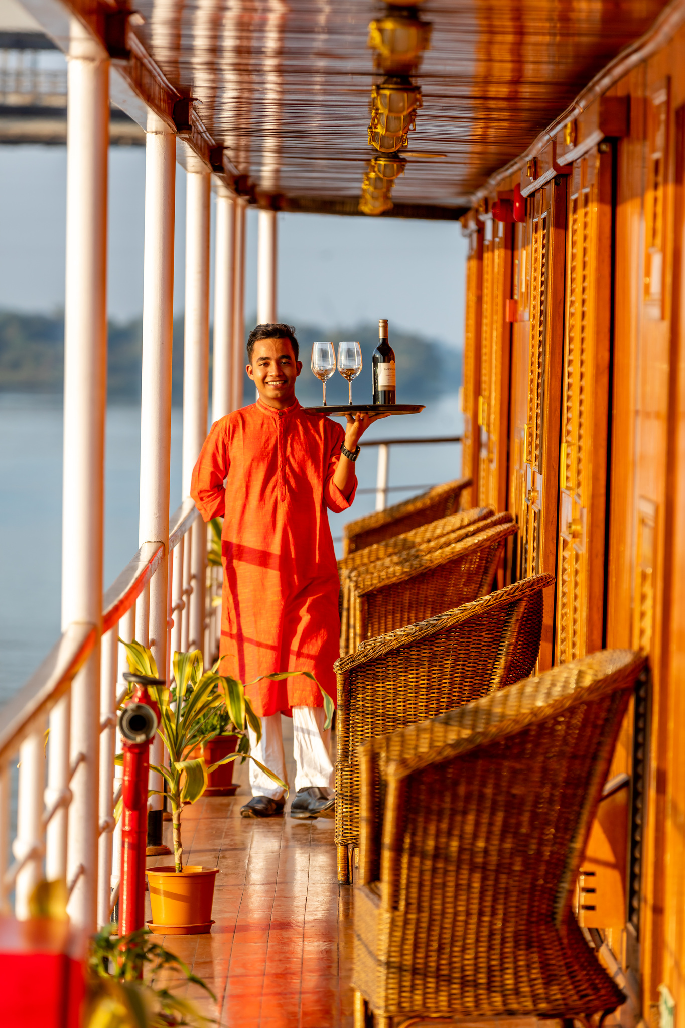 A steward carrying wine along the promenade deck