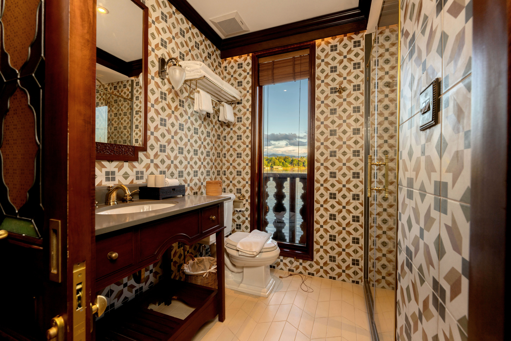 A tiled bathroom with a window on the river