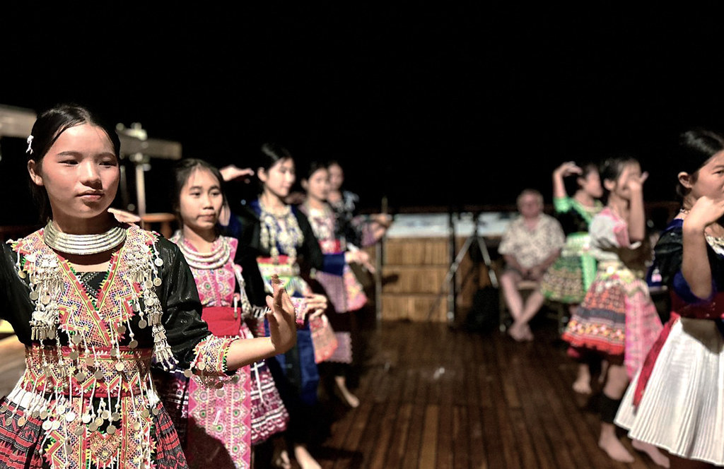 Hmong dancers performing on the terrace deck at night