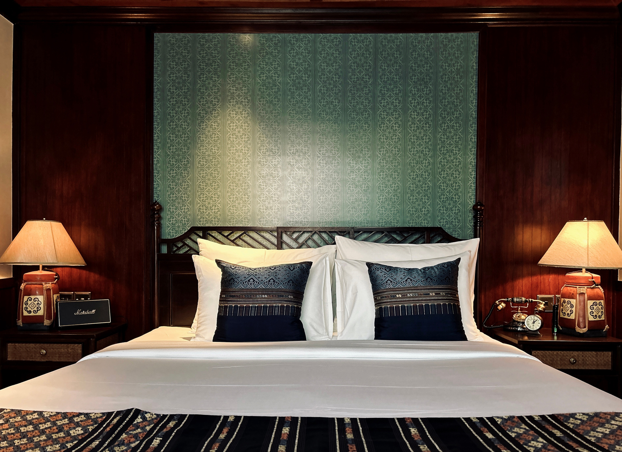 A stateroom bed made up with Lao silk cushions