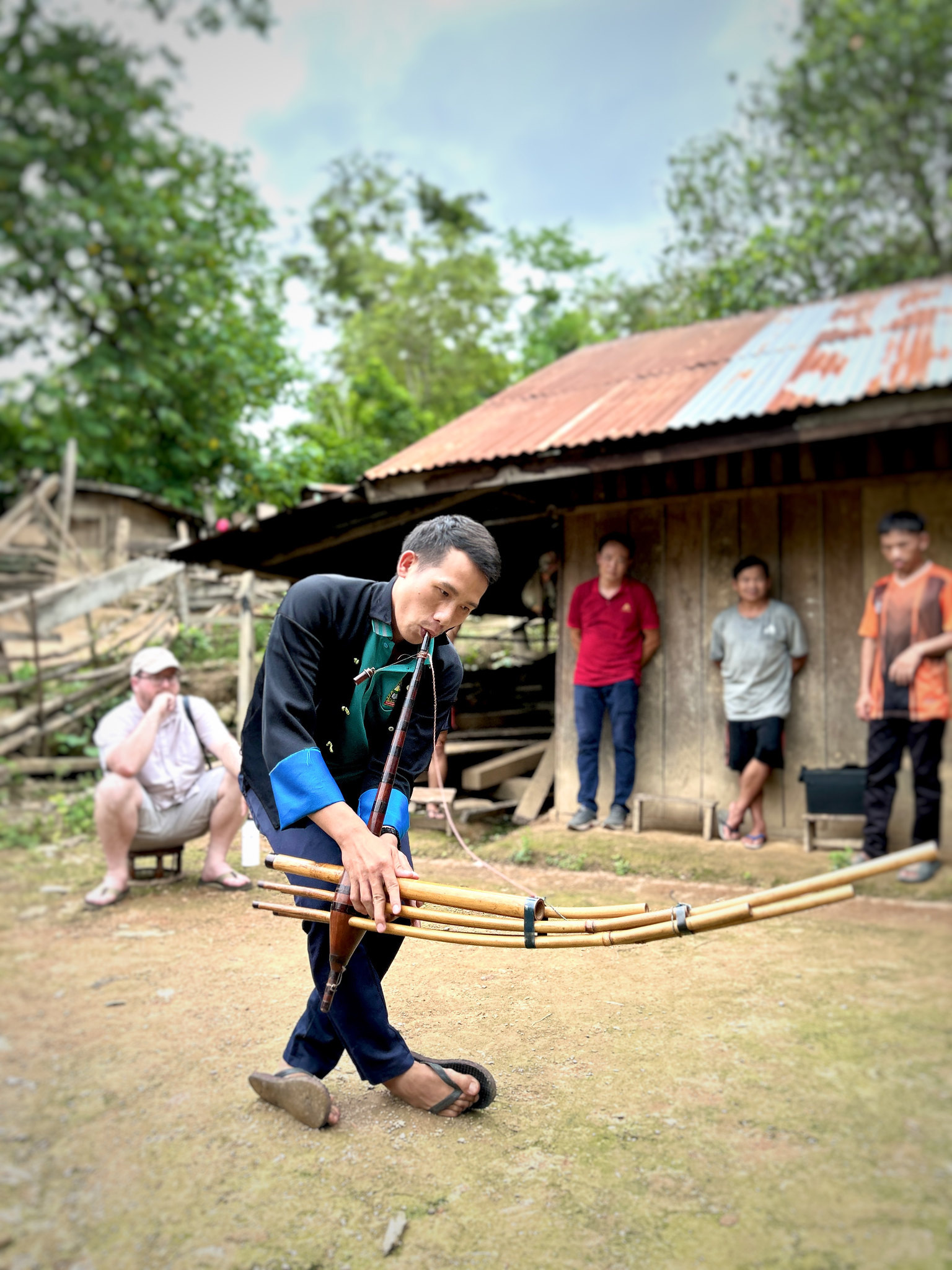 A Hmong musician dancing with bamboo pipes