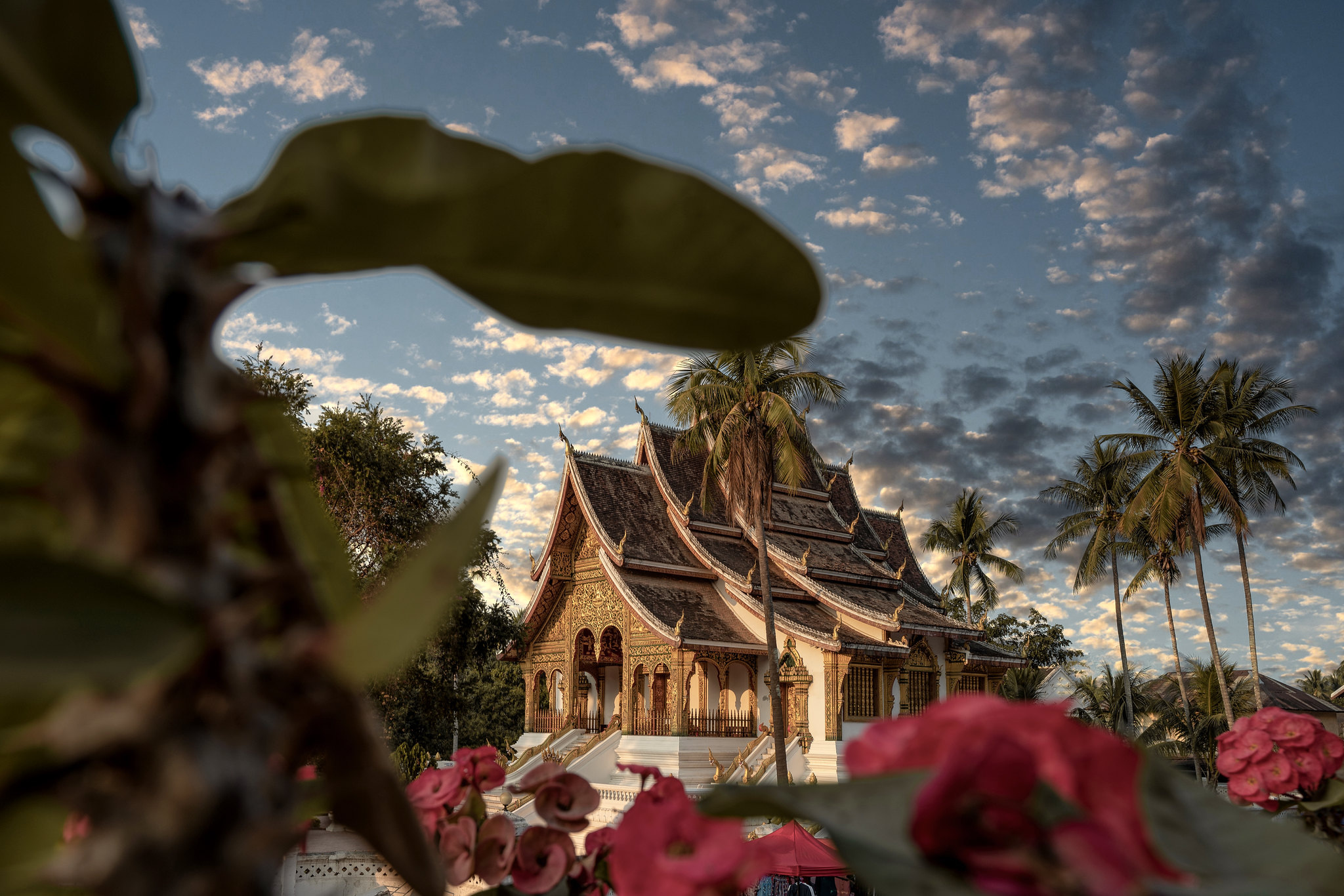 Haw Pha Bang in Luang Prabang, framed by red flowers