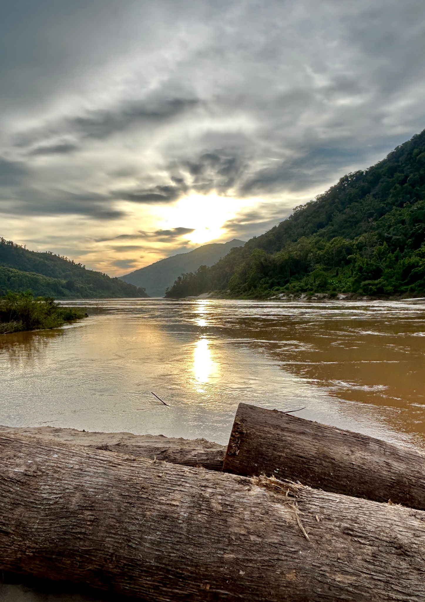Sunset over the Mekong from a driftwood beach