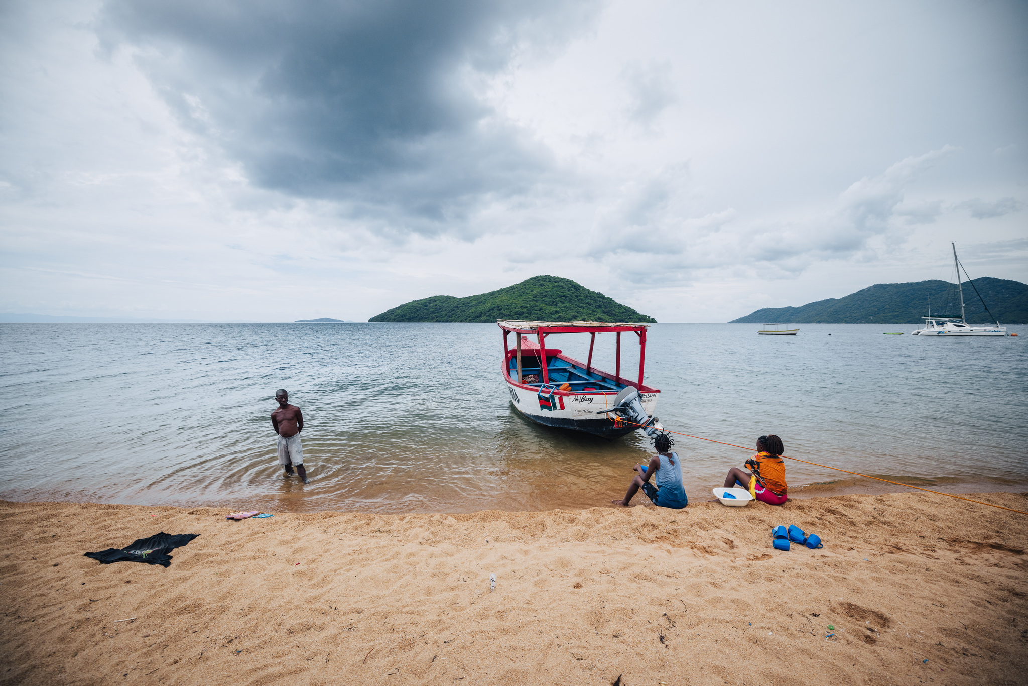 The beach at Cape Maclear, with a painted boat and the islands offshore