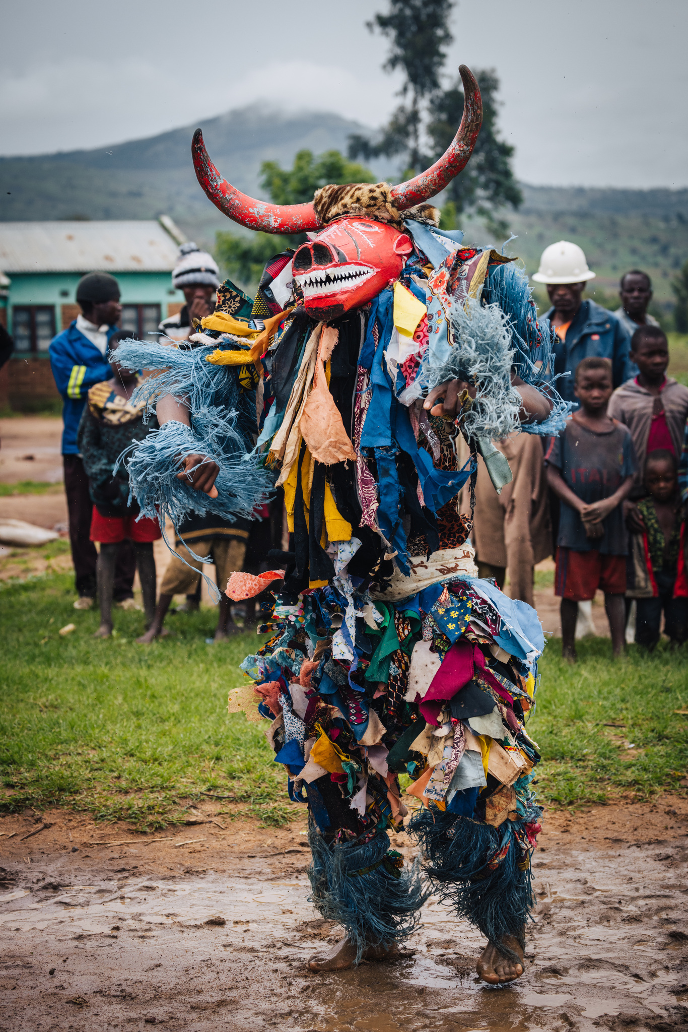 A horned Gule Wamkulu dancer in a costume of cloth strips