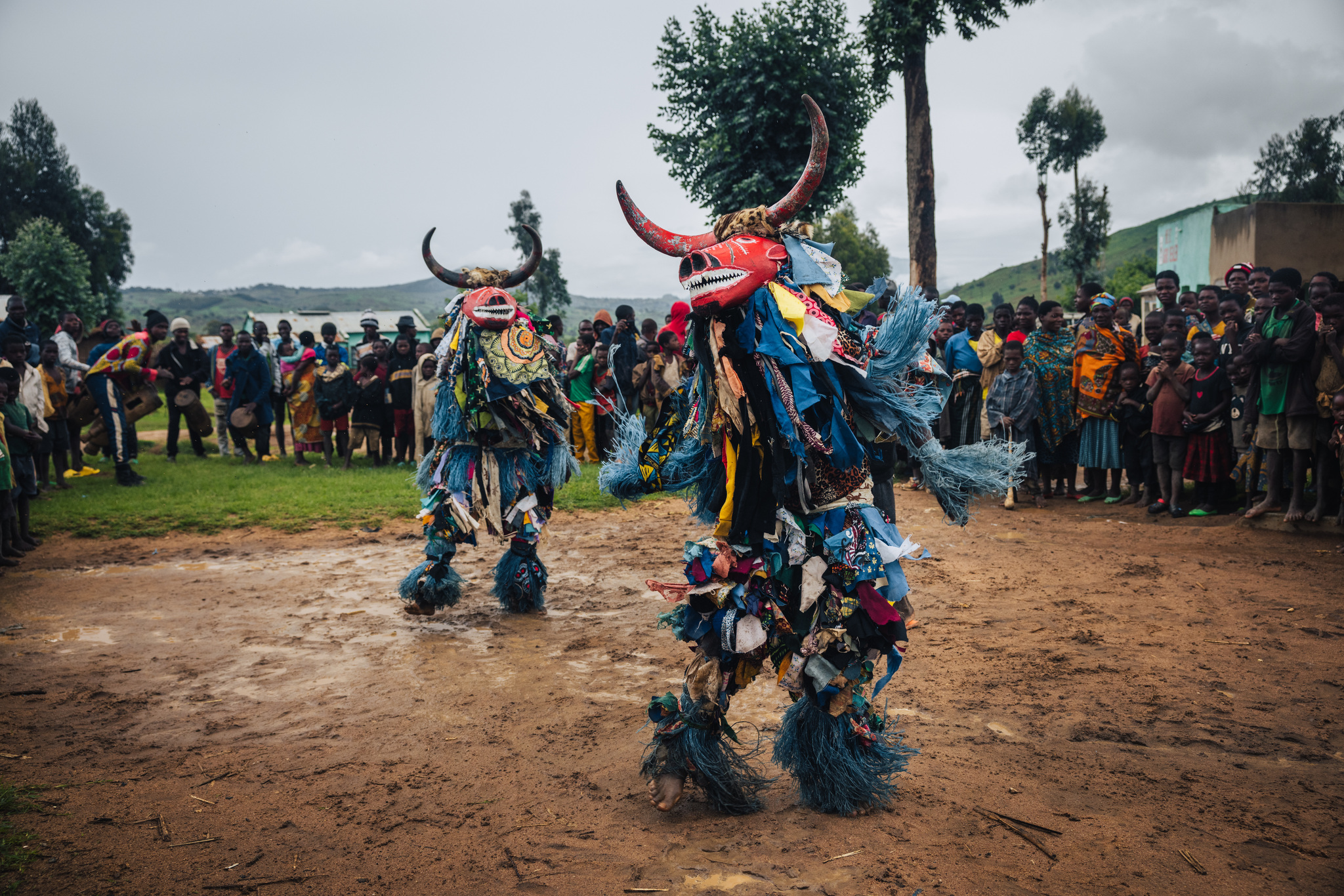 Two masked Gule Wamkulu dancers before the crowd