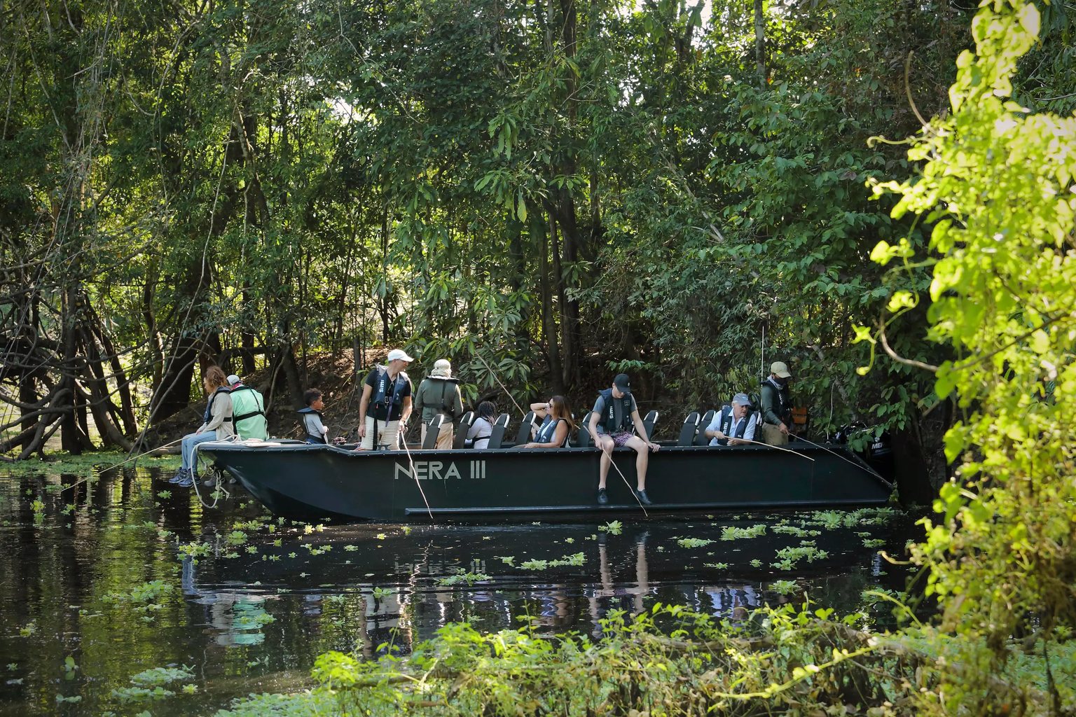 A skiff of guests fishing in the flooded forest